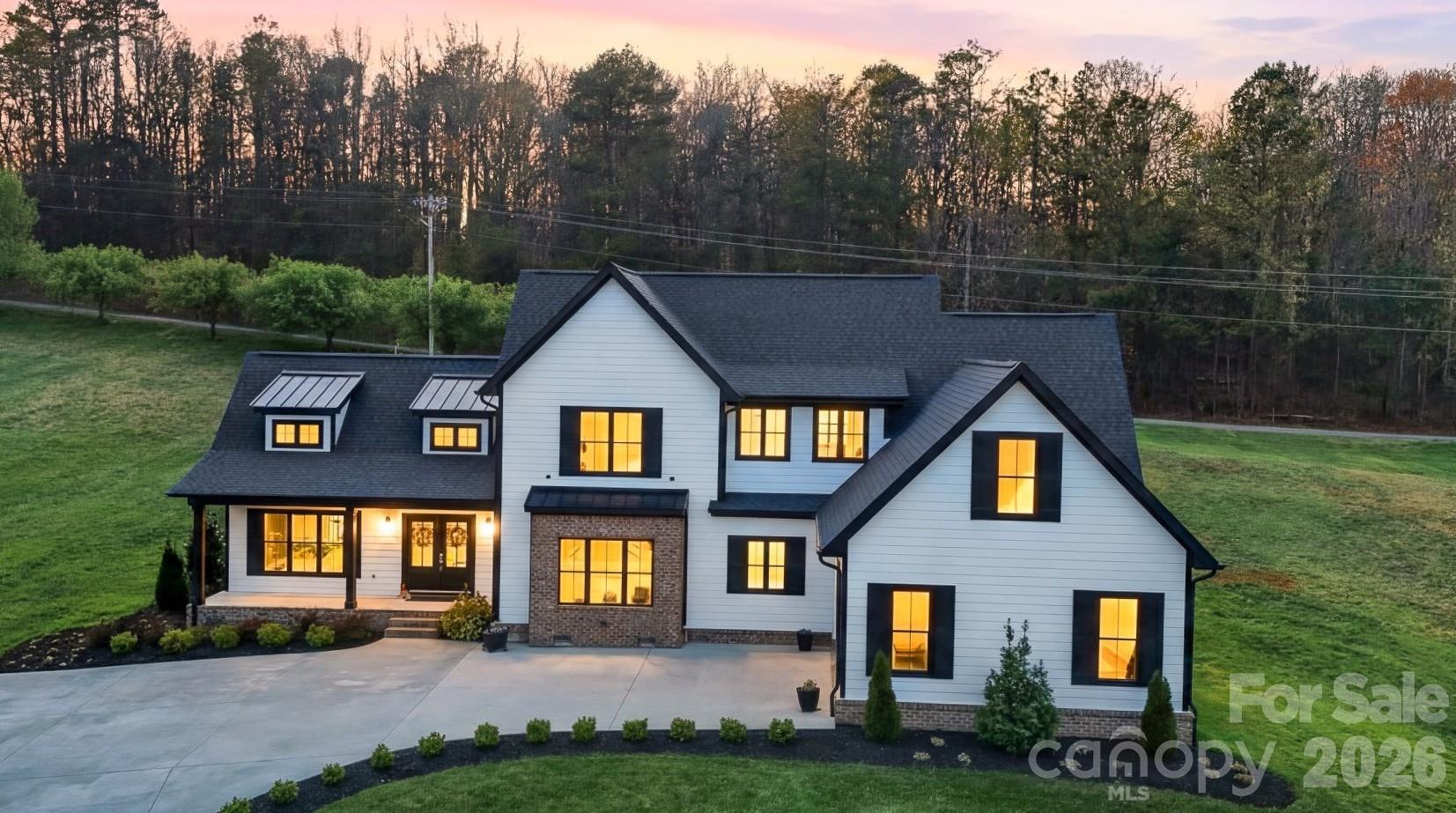 Price Improvement! This stunning 2022 modern farmhouse in Wittenburg Landing is filled with thoughtful design, upscale finishes, and all the bells and whistles to impress even the most discerning buyer. A charming covered front porch welcomes you into a breathtaking great room featuring soaring cathedral ceilings and a dramatic floor-to-ceiling fireplace mantel with electric insert, creating a warm yet sophisticated focal point. Throughout the home, you'll find beautiful wide-plank rustic but elegant farmhouse flooring, adding timeless character, warmth, and style to every space.

The open-concept layout captures views of both the front and back yards and flows seamlessly to the rear patio—perfect for relaxing or entertaining. The kitchen is the heart of the home, showcasing a massive center island, gas range with pot filler, open display shelving, custom cabinetry, and a spacious formal dining area just steps away. 

Tucked down a private hallway, the primary suite offers a true retreat with a soaking tub, tiled shower, double vanity, and an expansive walk-in closet. Just beyond, you’ll find an exceptional laundry room designed to make everyday living effortless, beautifully appointed with ample workspace and conveniently located off both the main hallway and the primary closet, making laundry feel less like a chore and more like a thoughtfully designed part of the home. 

The main level is completed by a double garage, mudroom, and half bath for everyday functionality. 

Upstairs, a loft-style den provides additional living space along with three generous bedrooms, each with private bath access, ideal for family or guests. 

Outside, professionally landscaped grounds sit on a generous 0.86-acre lot within a sought-after waterfront community, just 2 minutes from Taylorsville Beach. Enjoy the perfect balance of peaceful lakeside living and everyday convenience. Located just 15 minutes from Hickory, this home offers quick access to shopping, dining, healthcare, entertainment, and major employers. Commuters will appreciate the easy access to Hwy 16, I-40, Viewmont, Hwy 127, Statesville, and Charlotte, making it an ideal location for those seeking both tranquility and connectivity.

Whether you're searching for a luxury farmhouse near Hickory, spacious family home, or a move-in ready home in Alexander County, this exceptional property checks every box. Come experience the lifestyle, craftsmanship, and convenience that make this home truly one of a kind.