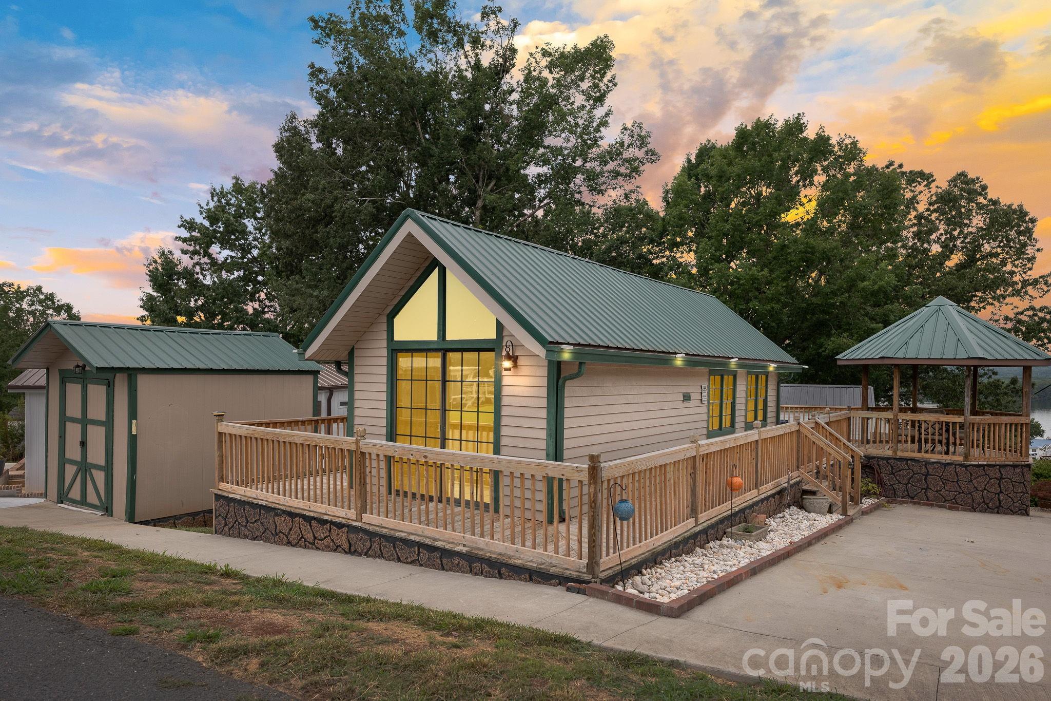 Come enjoy your morning coffee or an afternoon drink while sitting in the gazebo taking in the magnificent lake view. This beautifully remodeled Park Model home has one bedroom with a loft. Kitchen has solid surface counter tops with tile backsplash, stainless appliances, high vaulted ceilings, & vinyl plank flooring. Doors from the living room and bedroom go straight onto the wrap around deck. Large double corner lot (only one HOA due), covered Gazebo,  patio with firepit area and lots concrete of parking are just a few of the fantastic features this property offers. Whether looking for your own lake getaway or an investment property this property may be a perfect fit. You will also get to enjoy the resort restaurant, sandy beach & lake swim area, playgrounds, boat landing/ramp, waterfront boardwalk, swimming pool, basketball courts, putt putt, fitness room & many other great amenities that Badin Shores Resort has to offer.