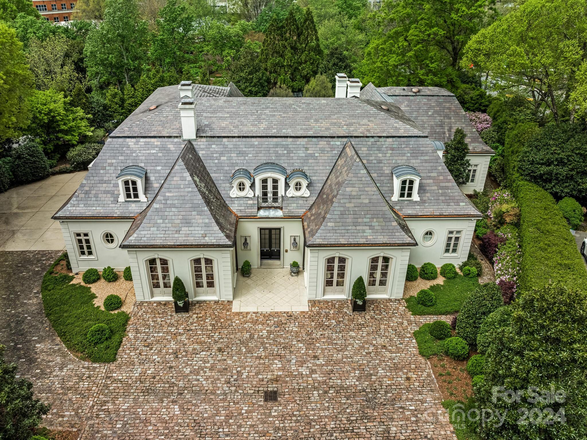 One of a kind stunning architectural masterpiece, designed by Milton Grenfell, includes carefully chosen details of custom moldings, arched doorways & windows. The slate roof, extensive landscaping, rose garden & saltwater pool further enhance the home's beauty and sophistication. Over 11 feet ceilings throughout the home, five fireplaces, custom cabinetry, mahogany Library, beautiful Bar w/ample cabinetry located between Kitchen & Dining Room add to the ambience of the home. Kitchen recently renovated by Bistany Designs- Calcutta marble countertops, Dutch Made Custom Cabinets, subzero refrigerator/freezer, Wolf microwave and gas range w/double oven/grill. Sitting area in the Kitchen overlooks the rose garden, swimming pool & loggia. The side door from the Kitchen leads you to the covered loggia w/ a fireplace. Primary bathroom/closets, renovated by Phil Goodwin & Bill Truitt custom cabinetry, incudes marble shower, marble flooring, his/ her sinks w/ calcutta gold marble countertops.