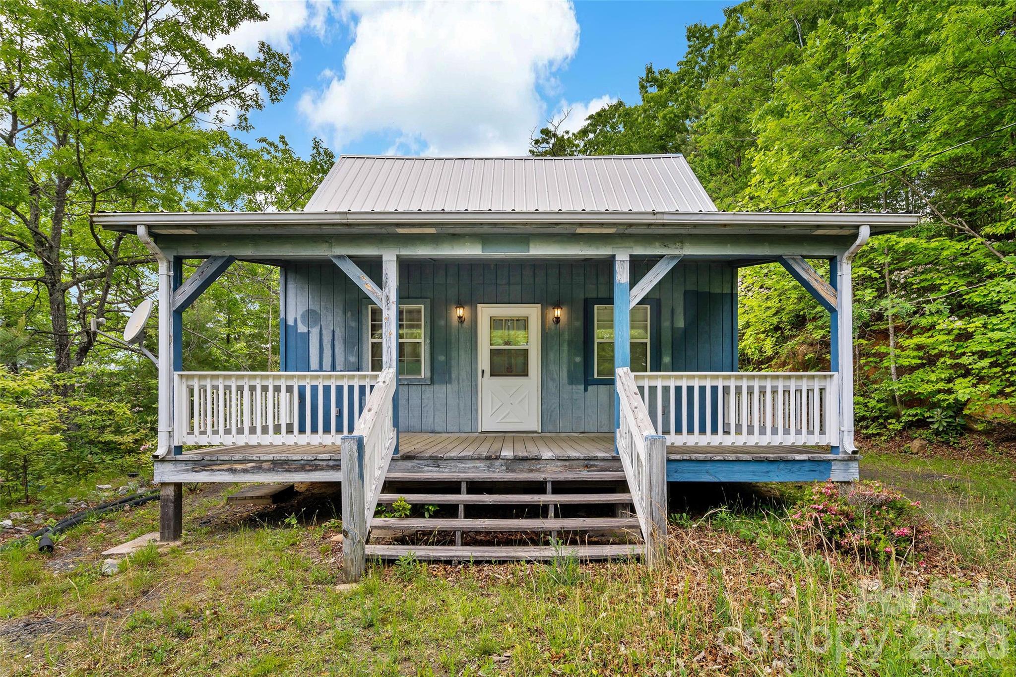 Here is the perfect vacation home located in the beautiful mountains of NC!  Nestlested in the community of Linville Forest, this home is ready for you to turn it into your dream mountain paradise. The main level is open, with a small kitchen tucked in the corner.  The windows bring in natural light and the loft makes a cozy area for a bed.  The bathroom is unfinished, but the owners left the tile and flooring, so finish it to your desire!  The square footage in the bathroom has been counted in the main level, just note it is plywood flooring.  Clear some trees and you will have a pretty view down the valley.  There is a beautiful flat rock in the backyard.  This is a cash deal, a septic is installed and the current owner has been catching rain water off the outbuilding and pumping it in the house to flush toilets and to use the sink.  Schedule a showing today!