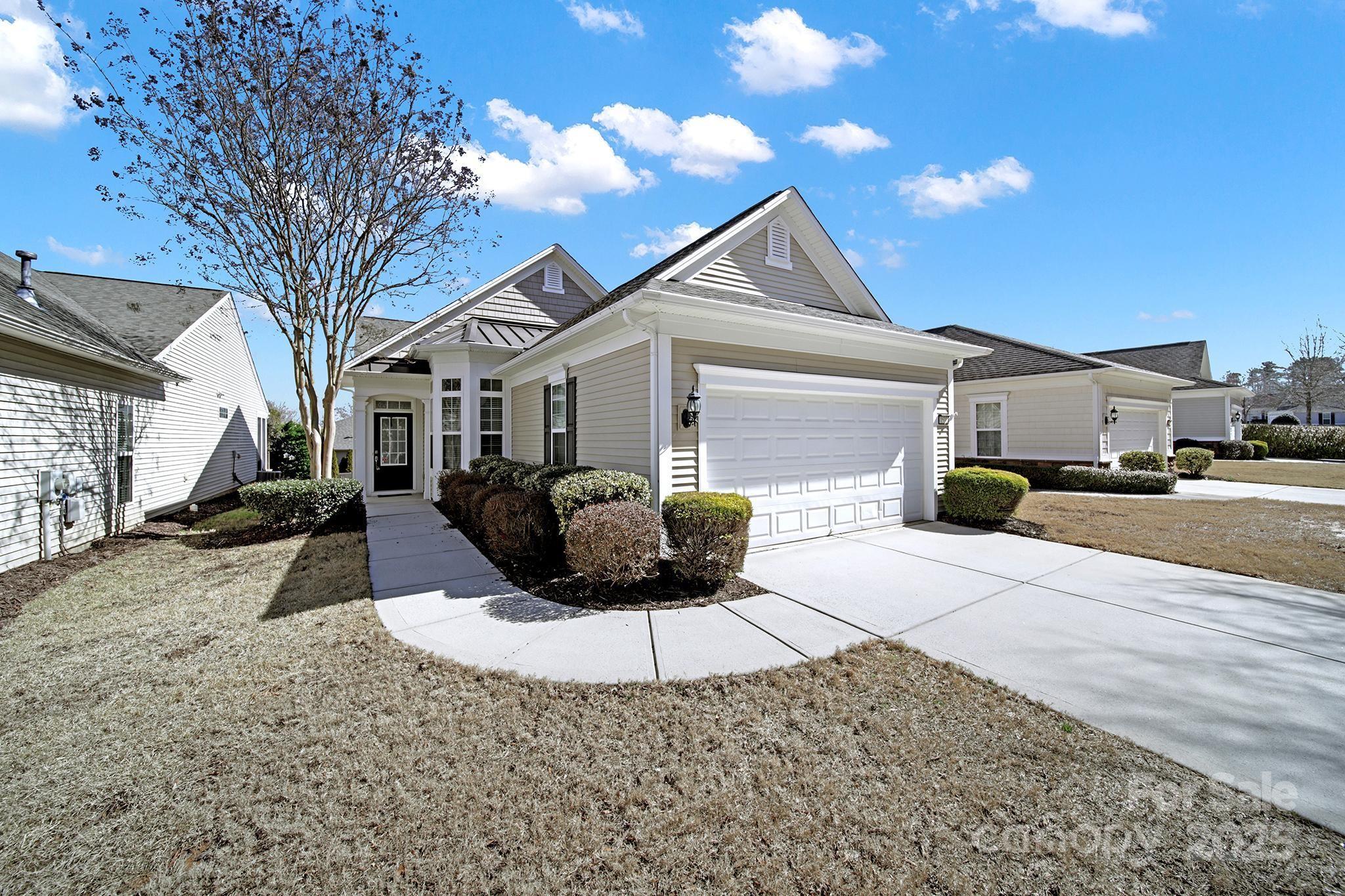 Move-in ready Gray Myst home in amenity-rich Sun City w/ easy access to the rear neighborhood entrance! Pre-finished wood flooring throughout & new carpet in the bedrooms! The eat-in kitchen features SS appliances, a gas range, a built-in desk area, & a sunny breakfast nook overlooking the front yard. Past the kitchen is the dining area & open great room, featuring crown molding & wainscoting accents. Sliding glass doors with screens open to the screened porch- a great spot for morning coffee or afternoon beverages! The primary suite is at the rear of the home & features an en-suite bathroom with a dual-sink vanity, glass enclosed shower, & walk-in closet! The guest bedroom has access to a full hallway bathroom, and there is also an office with double doors & a closet if you want to use it as a 3rd bedroom! Don't miss this great opportunity to join the active-adult lifestyle in Sun City and experience resort style amenities every day of the week!