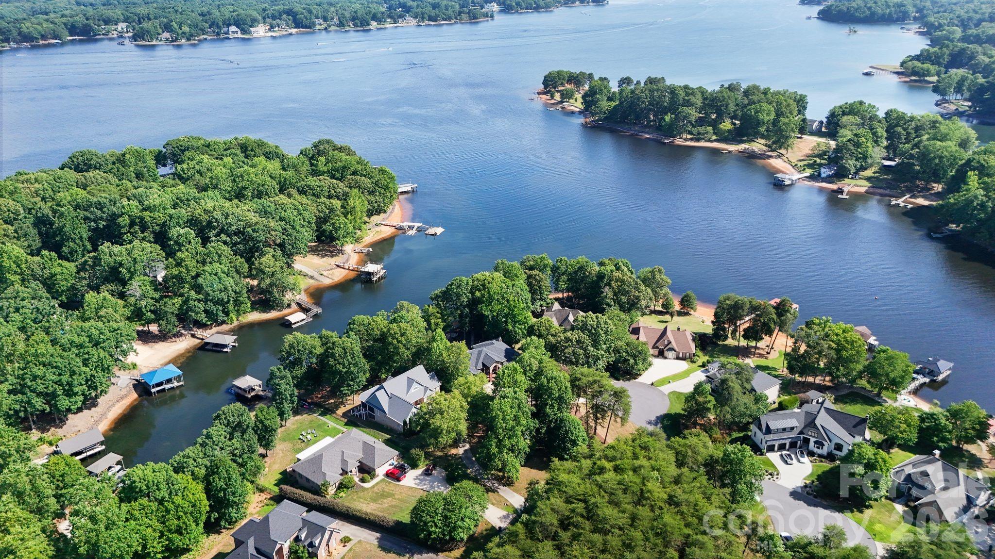 Experience the perfect blend of luxury lakefront living and refined mountain-inspired design in this fully renovated Lake Norman retreat. Thoughtfully reimagined from top to bottom, this home offers elevated finishes, timeless materials, and a seamless connection to the water.
Nestled in a deep water cove with long-range views of Lake Norman, this property delivers both tranquility and accessibility—just minutes to the main channel by boat.
From the moment you arrive, the striking stone front porch and architectural stonework create a bold first impression. Inside, the home opens to a light-filled interior featuring new windows, soaring ceilings, rich hardwoods, and stunning cedar posts and accents that bring warmth and character throughout.
At the heart of the home is a chef’s dream kitchen, showcasing a dramatic quartz island with breakfast bar, custom cabinetry, all-new stainless steel appliances, and a custom hood over the gas cooktop. Designer lighting and curated finishes create a sophisticated yet inviting space ideal for entertaining.
The primary suite is a private retreat, offering serene views of Lake Norman and a spa-inspired ensuite bath complete with a large walk-in shower, quartz countertops, heated floors and a thoughtfully integrated stackable washer and dryer for added convenience.
The two additional bedrooms have custom closets and share an exquisite jack and jill bath.
Additional features include:
Quartz countertops throughout
All new light fixtures
Beautifully updated baths and living spaces
Custom millwork paired with warm cedar detailing
Newly epoxied garage floor
Meticulously landscaped with lake fed irrigation system
Step outside to the new covered rear porch with cedar accents, perfectly positioned to take in the peaceful waterfront setting. The outdoor experience continues with a new dock and covered boat slip, making lake days effortless.
This home offers the best of both worlds—quiet cove living with long-range views and quick access to the main channel—all wrapped in a design that blends luxury lakefront elegance with a distinctive mountain-modern feel.