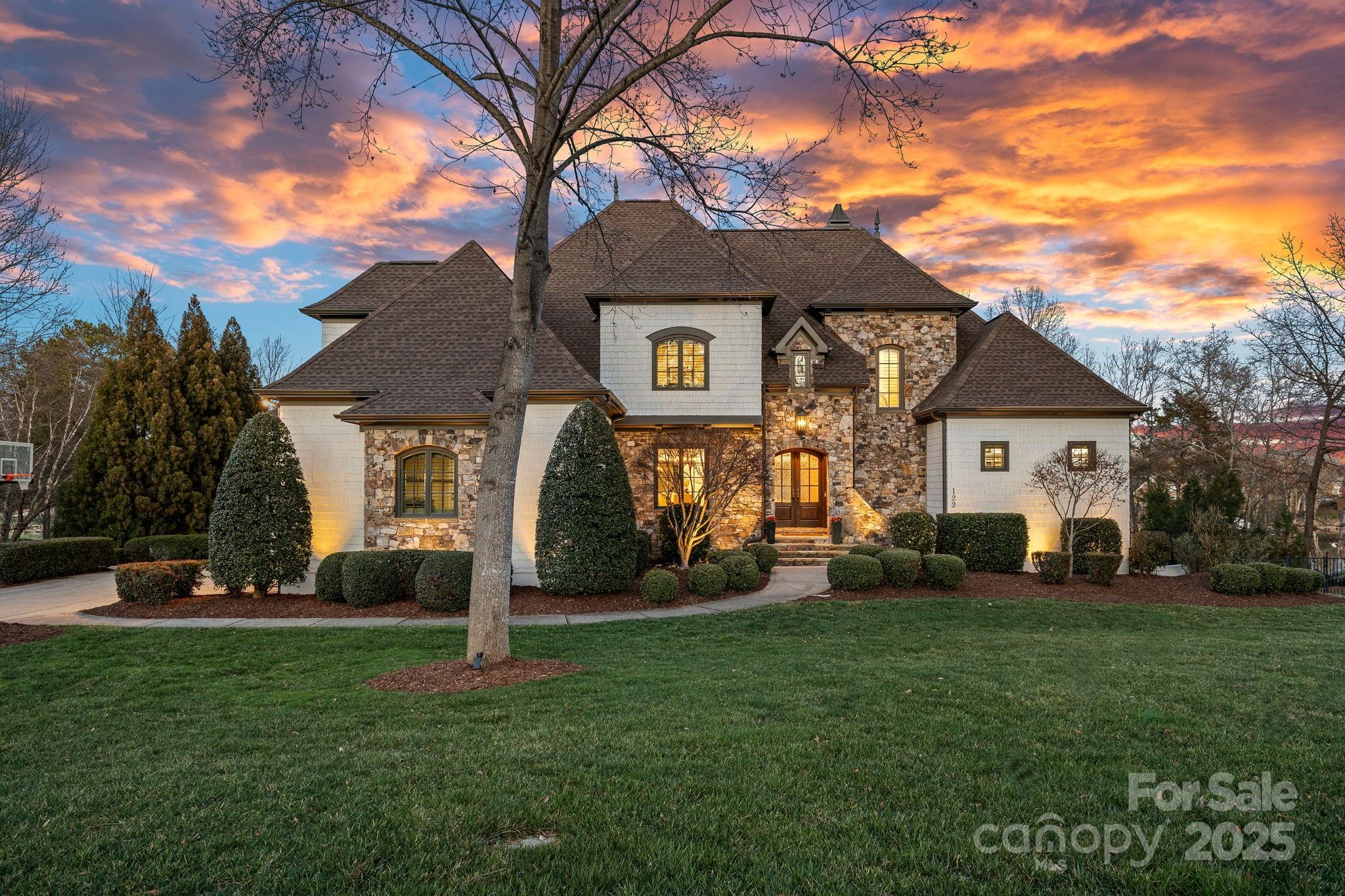 Nestled on 1.08 acres in the prestigious Point community, this stunning 3 level estate offers a perfect blend of luxury, comfort, and breathtaking views. Boasting over 7,300 sqft of updated living space, this home sits on a prime cul-de-sac lot with over 200 ft. of shoreline overlooking the notable 16th hole at Trump Golf Course. Designed for entertaining and everyday relaxation, the outdoor oasis features a heated saltwater pool w/waterfall, spa, flagstone-covered porch, gas firepit, private dock and sandy beach. Inside, no detail has been overlooked. The gourmet kitchen is a chef’s dream, equipped with Thermador appliances, built-in beverage drawers, and a Miele coffee system. Stunning main level owner’s suite w/relaxing bath and designer closet. 3 Bedrooms w/ensuite baths and bonus room on upper level. Remarkable lake level provides a 2nd kitchen, guest suite, wine cellar, exercise room, workshop and garage. A built-in elevator shaft provides options for future accessibility.