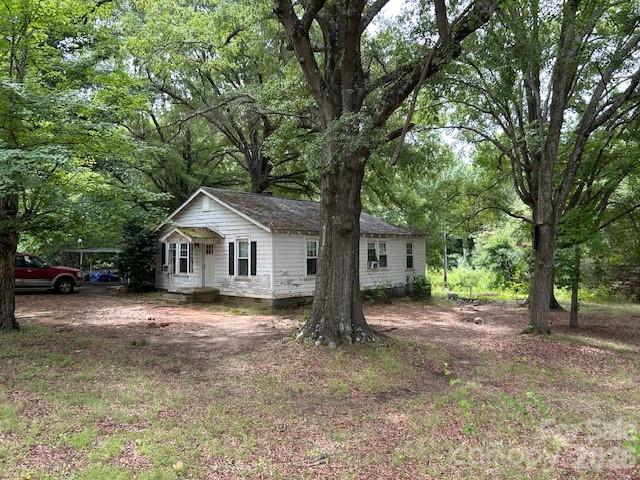 Discover nearly two acres of possibility just minutes from downtown Mooresville! Tucked away in a private tree-lined setting, this nearly two-acre property offers the rare combination of seclusion and convenience, all within close proximity to shops, dining, and the charm of Downtown Mooresville. Towering mature trees frame the land, creating a peaceful, established atmosphere that simply can’t be replicated. Whether you’re envisioning a private retreat, a custom build, or a renovation project, the possibilities here are wide open.
The existing 1,200 sq ft home is being sold as-is and presents an excellent opportunity for investors, flippers, or buyers with a vision. Cash purchases only. Bring your contractor and your creativity — the bones are there, and the setting is already exceptional.
