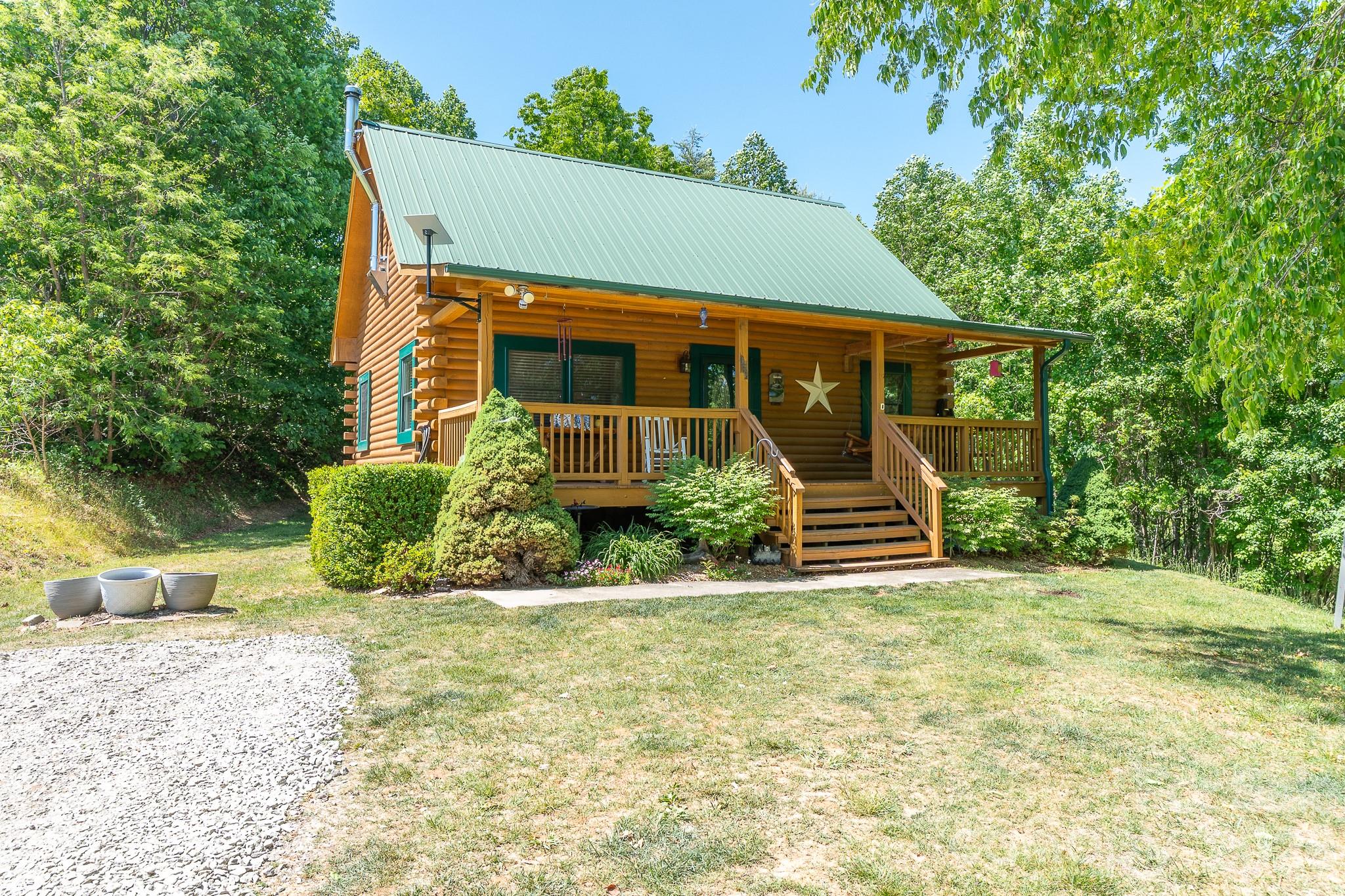Escape the hustle and bustle of city life and embrace the peace and tranquility of the mountains in this incredible 3BD/2BA log cabin retreat offering the perfect blend of privacy, comfort, and rustic charm. Nestled on 4.56 picturesque acres with the illusion of complete seclusion and end-of-the-road privacy, this property invites you to slow down and enjoy nature at its finest. Ample green space provides endless possibilities for gardening, outdoor entertaining, or simply enjoying the fresh mountain air on the incredible 32x8 Rocking chair front porch. Additional features include a woodworking shop/outbuilding,   and wood shed for all your hobbies and outdoor needs.  Inside, you’ll find a warm and inviting open floor plan filled with character, featuring vaulted tongue-and-groove ceilings, exposed beams, and a spacious great room centered around a cozy wood stove. The gorgeous kitchen offers stainless steel appliances, abundant cabinetry, and a large island with seating for three, flowing seamlessly into the dining area—perfect for gathering with family and friends. The main-level primary suite provides convenience and comfort with a walk-in closet, while laundry is also located on the main floor. Upstairs features two spacious guest bedrooms, a walk-in closet, and a full hall bathroom, creating the ideal layout for family or visitors. This charming mountain escape is the perfect opportunity to enjoy peaceful living without sacrificing modern comforts.