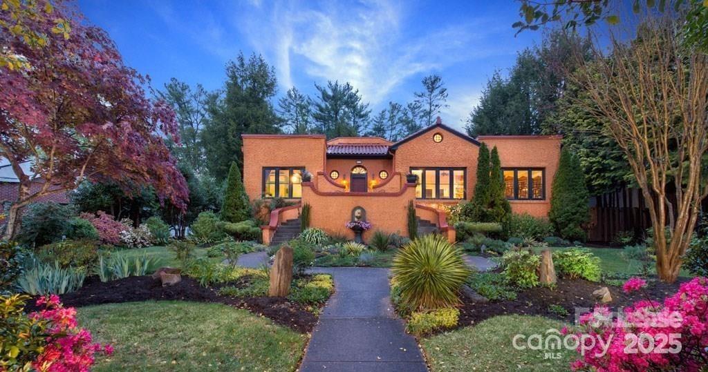 Step into timeless elegance with this 1920s Spanish Revival home nestled in the heart of desirable Kenilworth. Set on a professionally landscaped, oversized lot with lush gardens, this one-of-a-kind historic residence seamlessly blends classic charm with modern comfort. Featuring 4 bedrooms and 3.5 baths. Spacious primary suite with a Juliet balcony, home office on the main level, and gym and guest quarters on the lower level. The unique octagonal great room serves as the centerpiece, complete with a wood-burning fireplace—perfect for cozy evenings or entertaining guests. Formal dining with French doors. Modern kitchen with new Wolfe range. Light-filled living room with built in bookcases. Enjoy outdoor living on the covered veranda with its own fireplace and generous seating area ideal for outdoor entertaining. Thoughtfully designed for today’s lifestyle, the property includes radiant floor heating, ample storage, and a new roof (2022). Pet-friendly with a private drive, plentiful parking, and a 1-car garage. Just minutes to Downtown Asheville and historic Biltmore Village—this rare gem captures the best of Asheville living. 9 Duke St. (pin# 964895000000000) included and is a buildable lot.