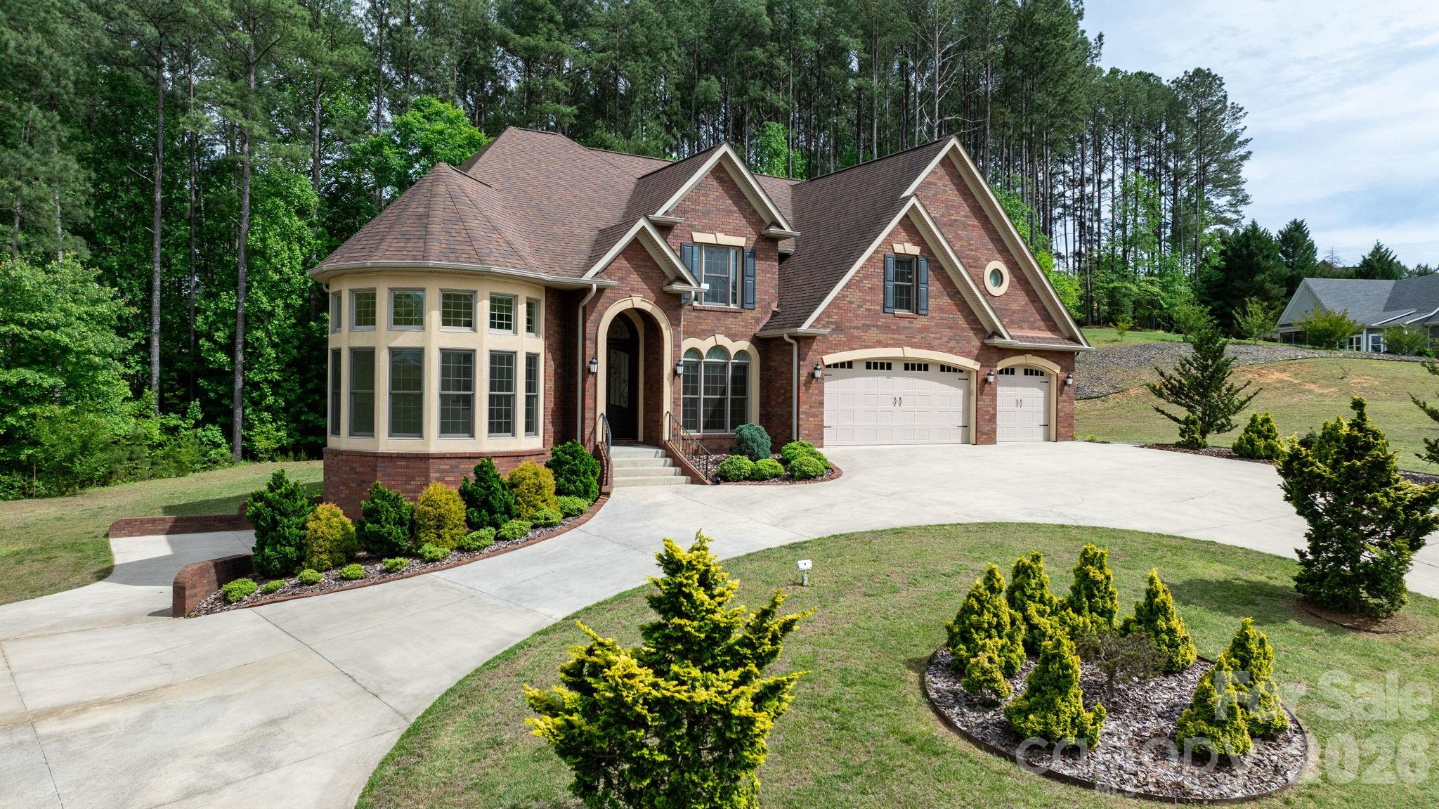 Welcome to 4 Royal Vista Way in River Bend, a premier Lake Hickory community in Granite Falls. This exceptional all-brick home offers 4 bedrooms, 6 full bathrooms, and approximately 4,575 square feet of living space in addition to a massive unfinished basement. A stunning, sun-filled parlor just off the entryway creates a memorable first impression, leading into a thoughtful floor plan that includes a formal dining room, a family room with a fireplace, and a kitchen designed for effortless entertaining.

The kitchen is a standout feature, boasting an abundance of cabinet and counter space, high-end stainless appliances, a high capacity vent hood, a gas cooktop, and a pot filler for added convenience. The open sightlines into the family room create an inviting, airy atmosphere that is perfect for hosting large gatherings. The main level also provides a convenient primary bedroom suite, an additional full bathroom, and a spacious laundry room.

The elegant staircase offers access from two directions, lending a stately presence to the home’s interior. Upstairs, the second primary bedroom serves as a true retreat with double doors, tray ceilings, and custom lighting. The highly appointed bathroom features a custom tile shower and a large vanity area overlooking the wooded area behind the home, while the walk-in closet offers generous proportions rarely seen in other homes. Two additional bedrooms, two more bathrooms, and a versatile bonus room provide ample space for family or guests to spread out.

The walk-out basement is a true blank canvas with high ceilings and a bathroom that is already finished and ready to go, making it easy to create a custom recreation area or additional living quarters. Set on approximately 0.89 acres, the property features a beautiful horseshoe driveway, generous parking, and an attached 3-car garage. Residents enjoy nearby community lake access, a boat ramp, and a well-hidden boat storage area across the street with options currently available. This location offers the best of both worlds, providing a peaceful community setting just minutes from the shopping, dining, and charm of Downtown Hickory.