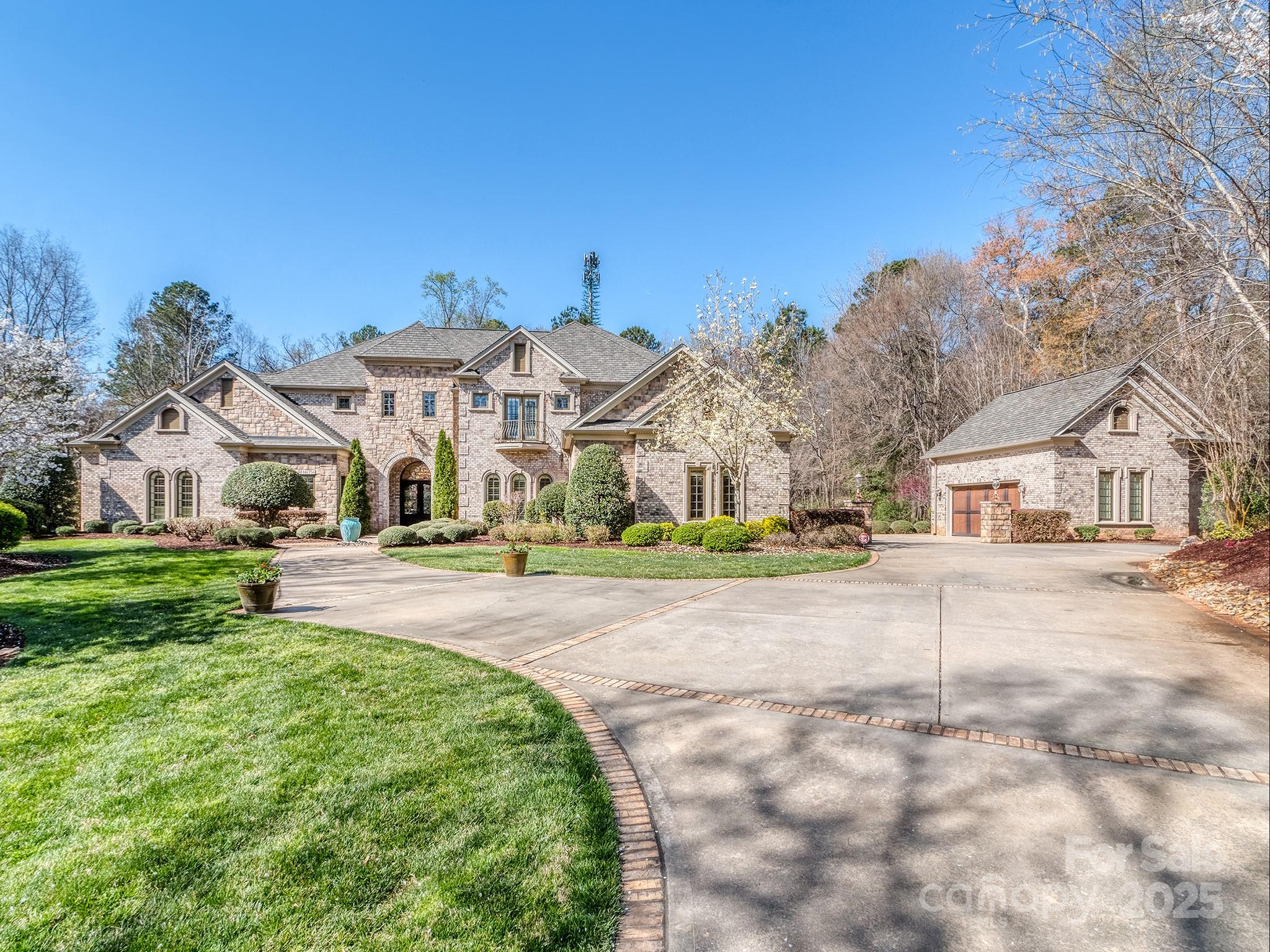 Situated on nearly 5 acres just minutes from Lake Wylie, this stately custom-built estate is both an entertainer’s dream & a private retreat. Boasting 5 bedrooms & over 7,500 sq. ft., it offers exceptional space for hosting in style. The main level features a luxurious primary suite, guest bedroom, & elegant formal living/dining room w/ vaulted ceilings & custom beams. The impressive two-story great room showcases a gas fireplace & a full bar w/ wine storage, wine refrigerator, ice maker, & kegerator. The chef’s kitchen is a masterpiece, featuring Wolf appliances, built-in espresso machine, spacious island w/ prep sink, & walk-in pantry. Designed for both relaxation & entertainment, this home includes a movie theater, gym with a sauna, & expansive outdoor living area. The covered patio is equipped w/ built-in grill, pizza oven, fryer, & wood-burning fireplace. Step outside to enjoy the resort-style pool and hot tub, all complemented by ample parking, & two 2 car garages.