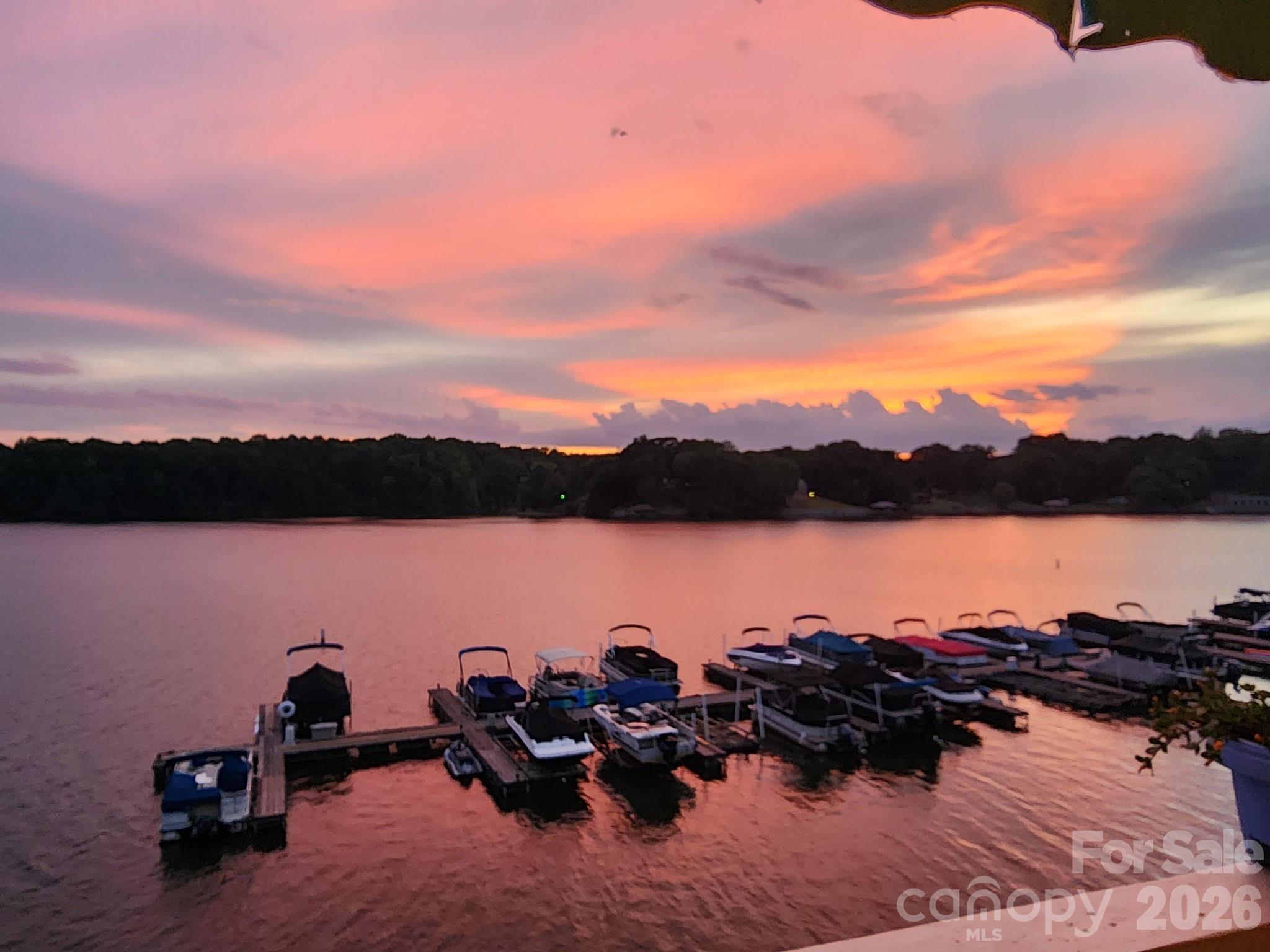 WOW! Panoramic main channel views of Lake Wylie and an assigned boat slip included! Experience lake life at its finest in this rare two-story waterfront condo at Emerald Point. This beautifully updated unit features new flooring, new stainless-steel appliances, updated fixtures, and fresh paint throughout. Enjoy breathtaking sunsets from either your upper or lower deck while taking in the expansive views of Lake Wylie. The unique lower-level living space is perfect for entertaining after a day on the water. Pull your boat into your dedicated slip, stroll along the boardwalk, and gather with friends at your private bar area. A spiral staircase connects both levels and provides access to the upper deck, creating the perfect indoor-outdoor lakefront lifestyle. Residents of Emerald Point enjoy fantastic amenities including a community pool, marina, kayak and paddleboard storage, and direct lake access. Conveniently located just minutes from the airport, Charlotte Premium Outlets, I-485, and a variety of shopping and dining options, this property offers the perfect combination of waterfront living and city convenience. Whether you’re looking for a full-time residence, a weekend getaway, or investment opportunity, this Lake Wylie gem is one you don’t want to miss!