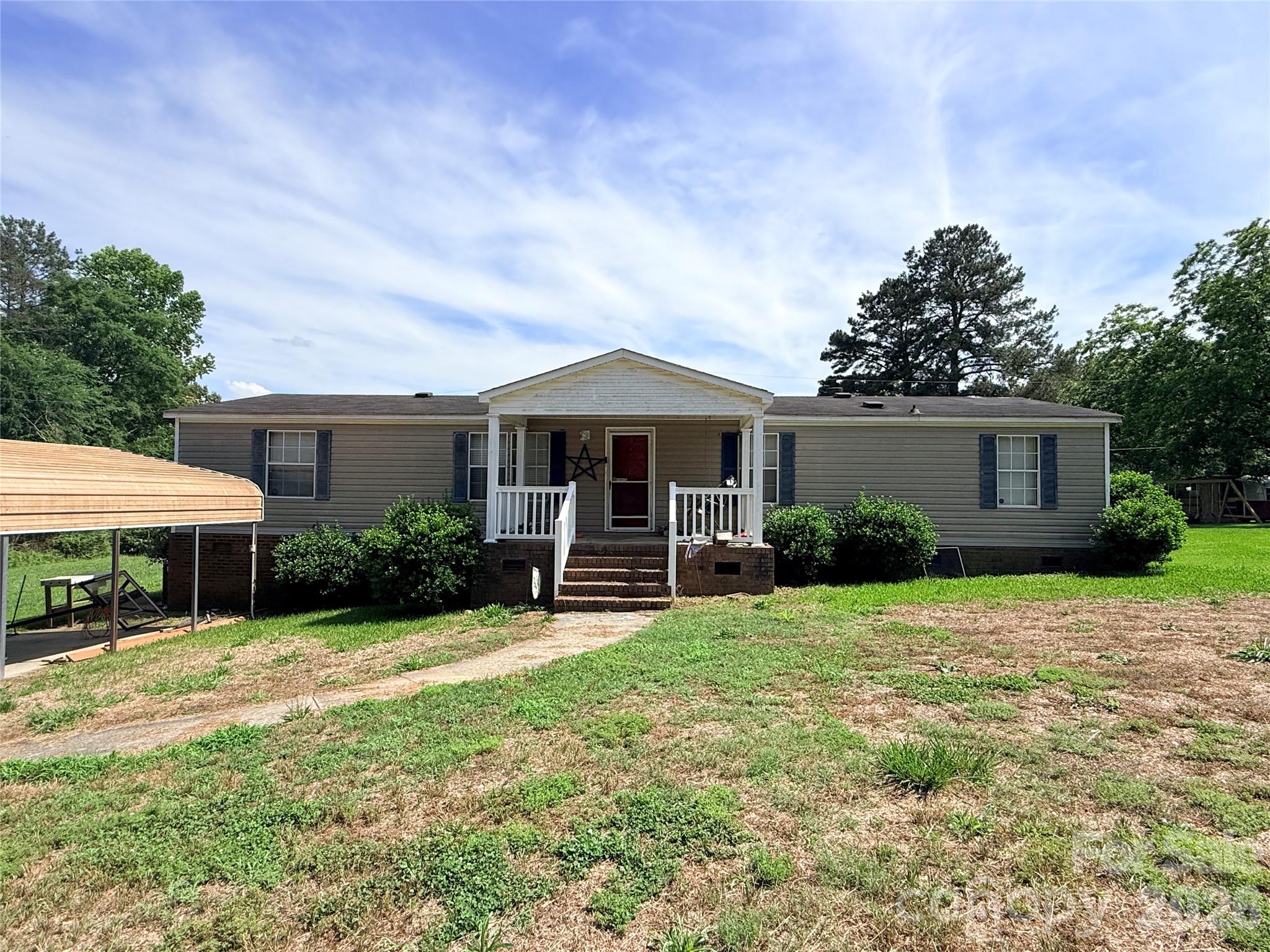 3 bedroom, 2 bath double wide featuring a split-bedroom floor plan, spacious living room plus separate den, and cathedral ceilings in the main living area. The kitchen offers ample cabinet space and opens to the living areas for an easy flow. Enjoy the covered front porch and manageable .25-acre lot with convenient outdoor space. Great opportunity for buyers looking to make a home their own or add to an investment portfolio.