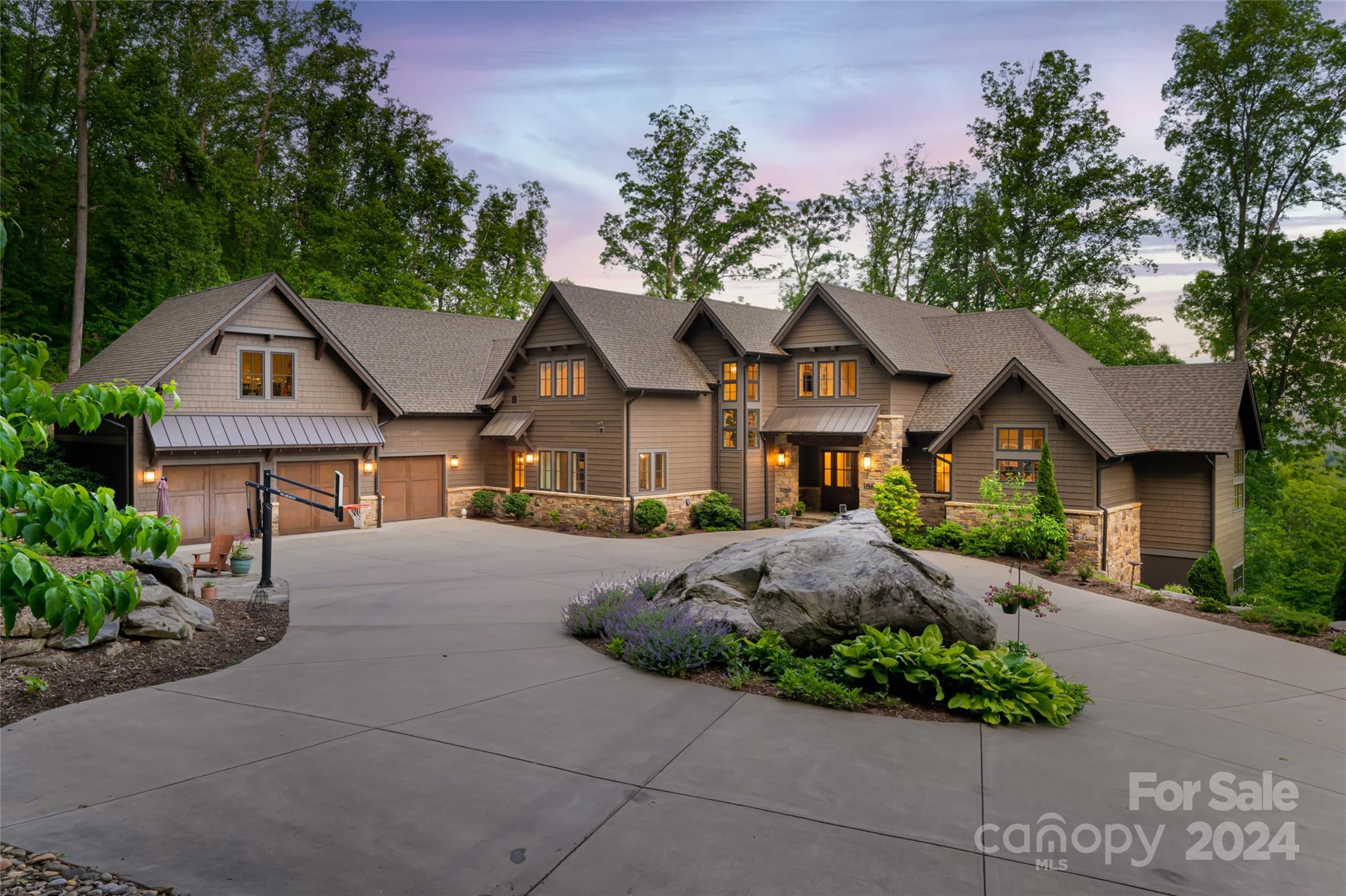 Situated on a private 4.18-acre homesite, this nearly 7,000 SF home offers spacious, yet comfortable living. The main level boasts a luxurious primary suite, an office, a soaring great room with a gas fireplace and wall of windows, an entertaining kitchen with seating, guest suite, and enjoy year-round mountain views from the screened porch that offers a fireplace, wet bar, and disappearing nano doors that blend indoor comfort with the great outdoors. The upper level features three guest suites and a recreation room. The lower level includes a full kitchen with bar seating, a gym, a recreation/family room, a locked safe room, and a golf simulator room that could easily convert to a home theater. With another nearly 1,000 SF of conditioned space to finish your way, there are endless possibilities. Southcliff offers a pavilion, a firepit area, and walking trails, all safeguarded by 24/7 manned gated security. Experience luxury, privacy, and the perfect blend of indoor and outdoor living.