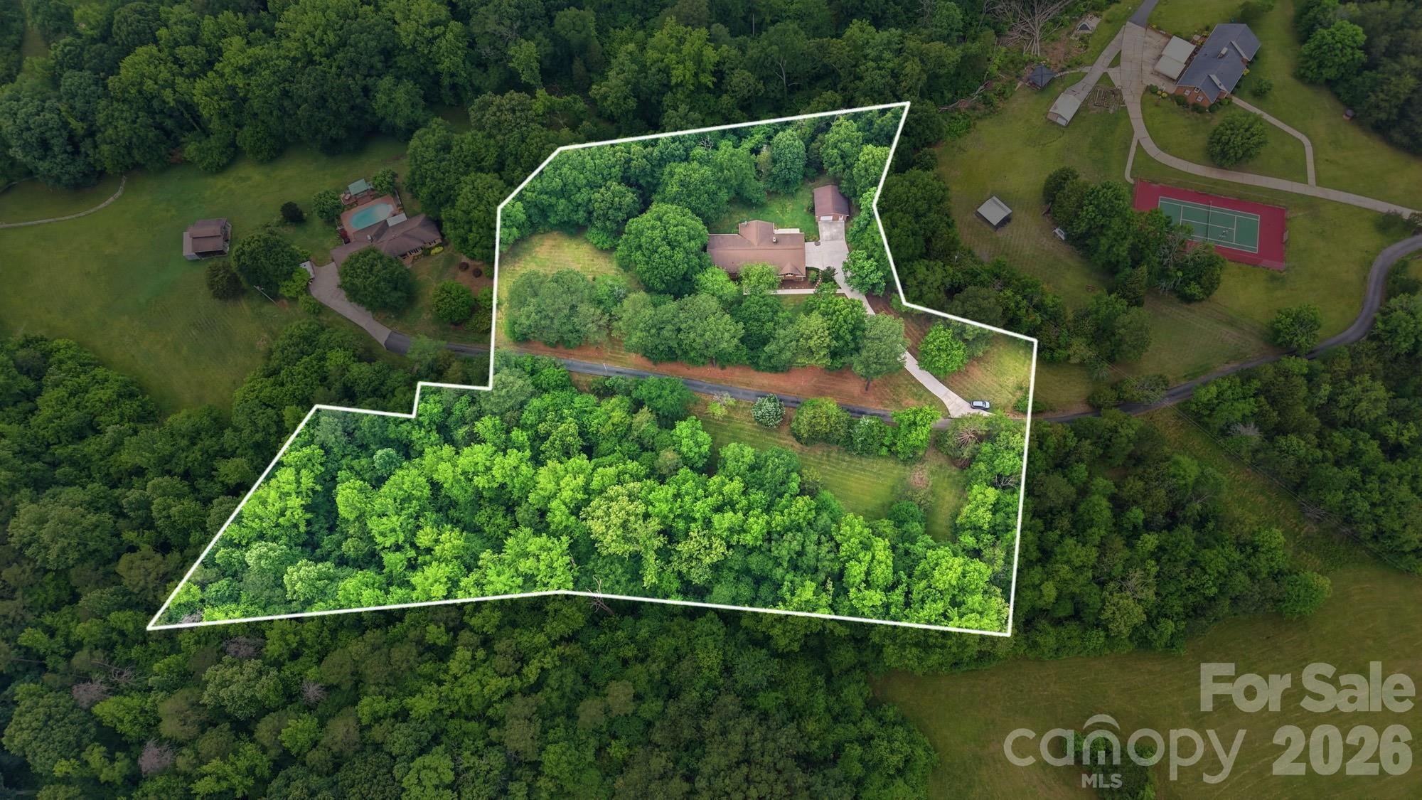 Welcome to 201 Hickory Hill Lane, a timeless all-brick ranch nestled atop a gentle hill and surrounded by the perfect blend of open pasture and mature woodland. Situated on just over 4 acres, this one-family-owned property has been cherished for nearly 50 years, serving as the foundation for countless memories and a lifetime of love.

Conveniently located just 25 minutes from Charlotte and only 10 minutes from downtown Mount Holly, Stanley, and the intersection of NC Highway 16 and NC Highway 73, this property offers the rare opportunity to enjoy peaceful country living without sacrificing accessibility.

From the moment you travel down the private winding drive through rolling pastures, you’ll feel a sense of arrival. The setting is truly special, a place where nature’s beauty unfolds in every direction and everyday life feels a little more relaxed.

Inside, you’ll find a warm and inviting three-bedroom, two-bath floor plan designed for comfortable living. One of the home’s standout features is the expansive 11’ x 24’ sunroom, offering panoramic views of the surrounding landscape and an ideal place to enjoy morning coffee, watch wildlife, or simply unwind.

The oversized attached two-car garage provides exceptional functionality and includes a heated and cooled flex space perfect for a home office, craft room, hobby area, workout space, or climate-controlled storage.

Adding even more versatility is the detached all-brick garage, ideal for additional storage, a workshop, recreational space, or potential conversion into guest quarters or a secondary living area.

More than just a home, 201 Hickory Hill Lane is a private retreat, a place of refuge, peace, and lasting memories. If you’ve been searching for a property that offers room to breathe, space to explore, and a setting you’ll never tire of coming home to, this is it.