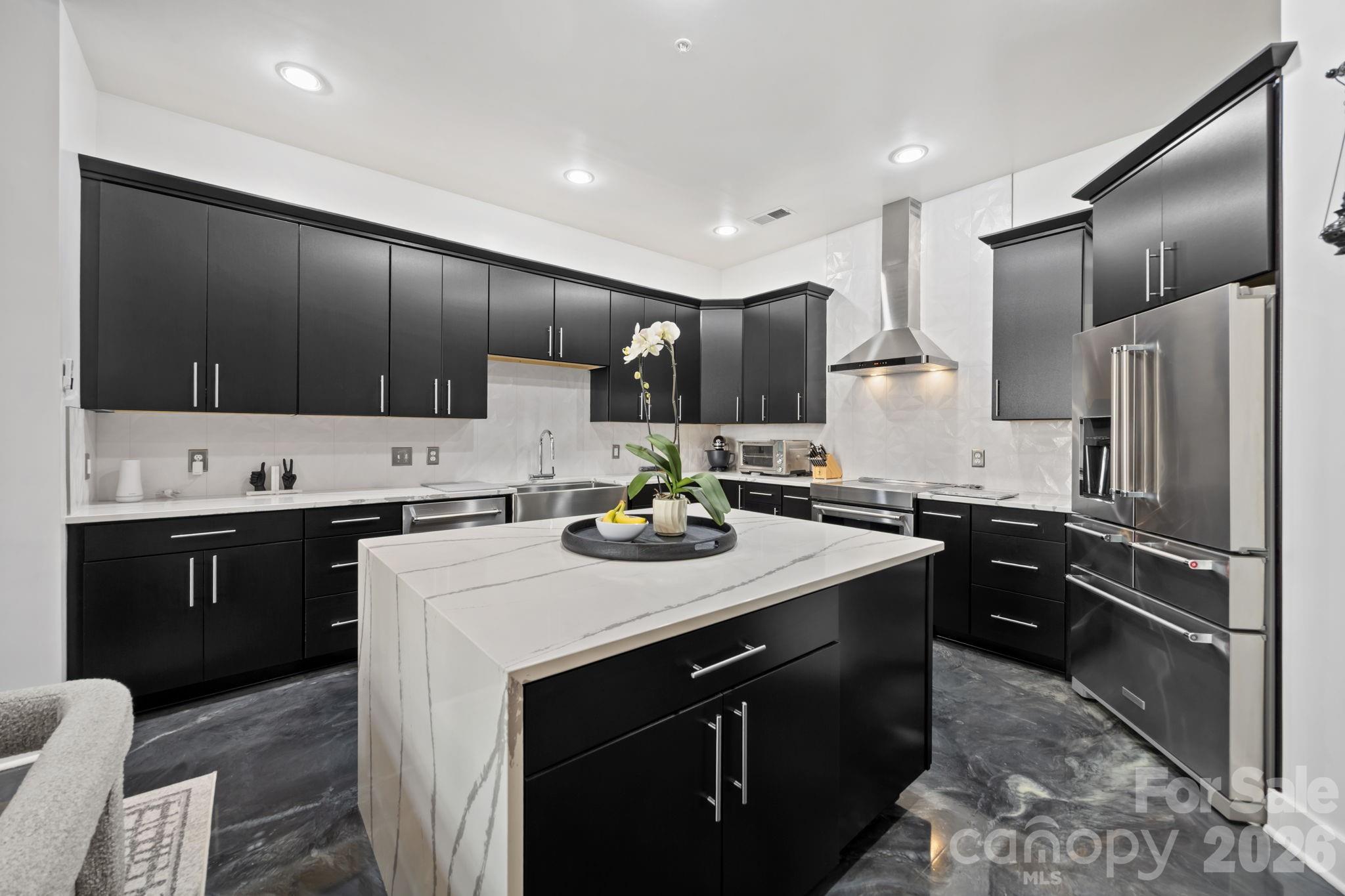 Experience unparalleled urban luxury in this meticulously reimagined 2,000+ square foot condo, perfectly positioned immediately adjacent to Charlotte’s highly anticipated Iron District. Inside this expansive 1.5-story residence, a sophisticated, transitional masterpiece awaits. The main level is defined by striking epoxy resin flooring that flows seamlessly through the open floor plan. The centerpiece of the home is a fully gutted, true chef’s kitchen designed for the culinary enthusiast. It features an elite KitchenAid appliance suite—including an electric induction range and a 5-door refrigerator—custom cabinetry with extensive organizational rollouts, and a stainless steel Vigo farmhouse sink with a cutting board inlay.

Upstairs, new stain-resistant carpeting leads to the ultimate private retreat. The primary suite features a highly customized walk-in closet outfitted with rollout jewelry shelves, dedicated shoe shelving, and reinforced steel rails. The primary bathroom has undergone a full-gut transformation into a resort-caliber spa, showcasing a reinforced quartz stone tub, an extended shower with dual rain heads, a custom anti-fog LED mirror, and a sleek quartz vanity. The guest bath is equally impressive, boasting modern fixtures and a Bluetooth-enabled ventilation and lighting system.

No detail or system was overlooked in the modernization of this home. State-of-the-art infrastructural upgrades include a UV-sanitizing HVAC system with app control, an electric tankless water heater, repaired motorized ventilation windows, and fully updated electrical with integrated USB outlets throughout. Complete with a dedicated laundry area featuring steam-setting LG appliances and custom cabinetry, this Skybox property offers a flawless, turn-key lifestyle at the very forefront of Charlotte's most exciting new development corridor. HOA plans to replace roofs in the near future. No vote or final assessment amount has been determined yet.

IMPORTANT: The original warehouse structure was constructed in 1964. The building underwent a complete adaptive reuse and was officially converted into residential luxury lofts in 2007 based on our research.