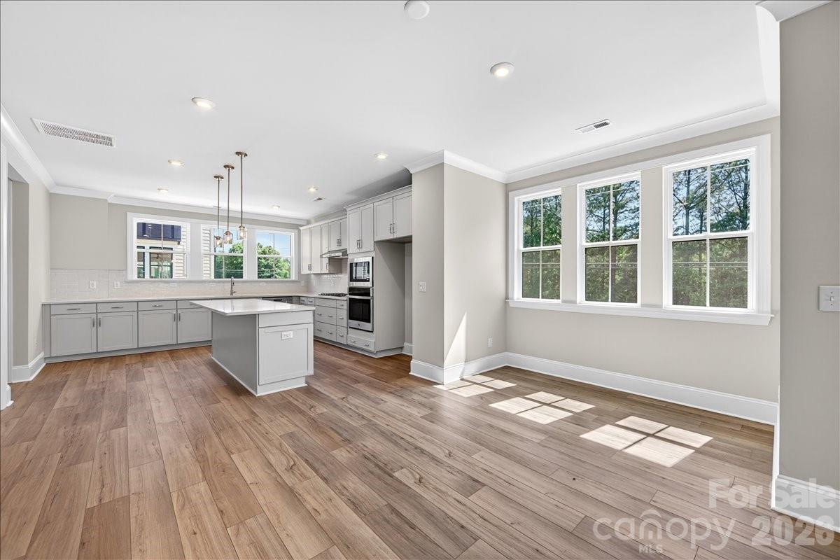 This spacious end-unit Regent townhome is designed for functional, elevated living. The first floor offers multigenerational living or a private guest suite with full bath and separate living area. The main living floor flows seamlessly from room to room, anchored by a gourmet kitchen with frost cabinetry, stainless hardware, and quartz countertops. Upstairs, the primary suite features 9-foot ceilings, 8-foot doorways, a spa-inspired en suite bath, and an oversized walk-in closet. A private covered outdoor living space completes this thoughtfully designed home.