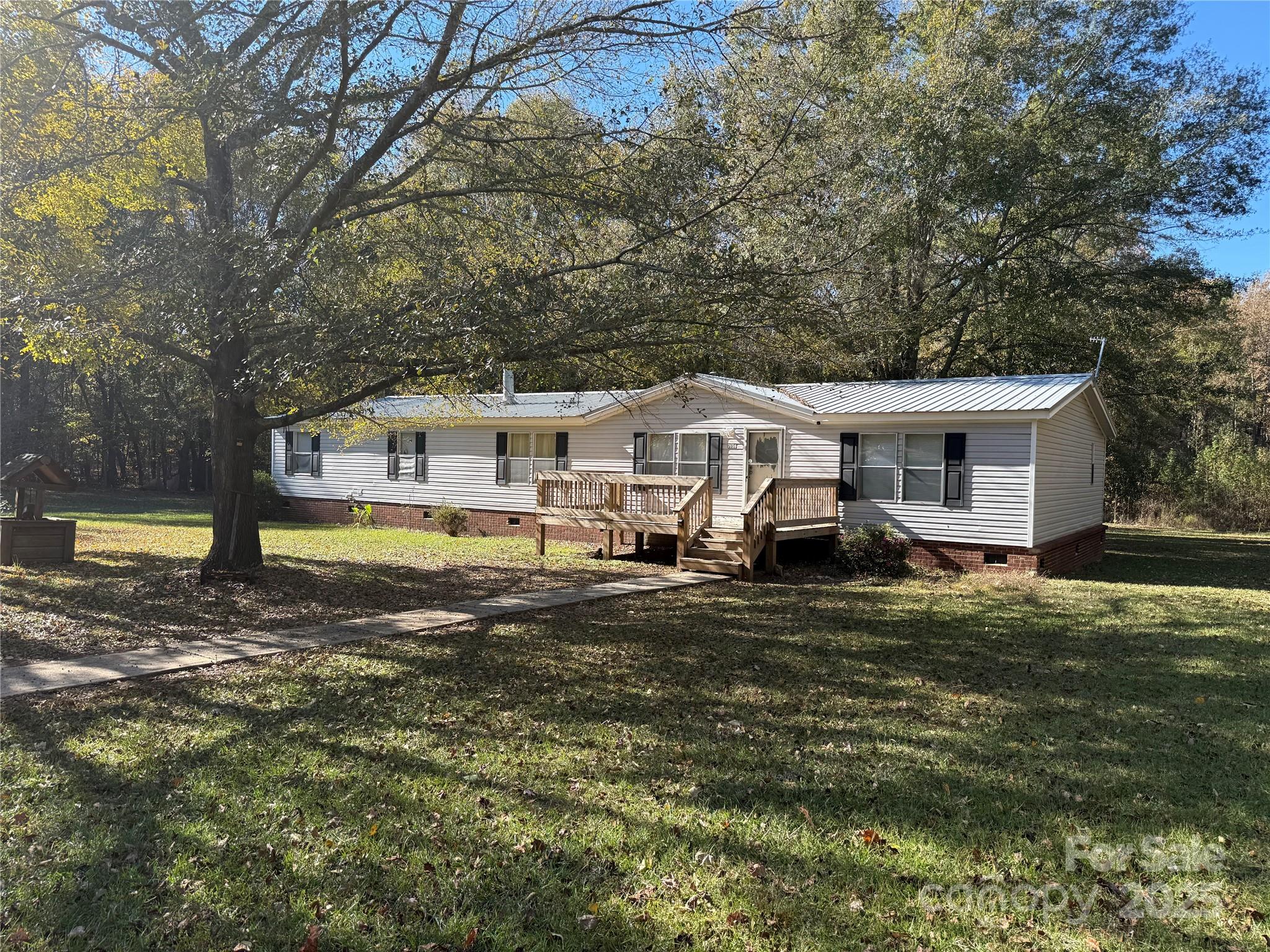 Enjoy peaceful country living on 6 acres with this spacious 4BR/2BA home offering approx. 2,560 sq ft. Open floor plan features a wood-burning stove and gas-log fireplace. Kitchen has plenty of cabinet and counter space and opens to the dining area. Split-bedroom layout includes a private owner’s suite with large bath and walk-in closet. Relax on the back deck overlooking a large backyard. Property includes an outbuilding and a double garage/workshop for storage or projects. Quiet, private setting just minutes from Kershaw and Lancaster.
