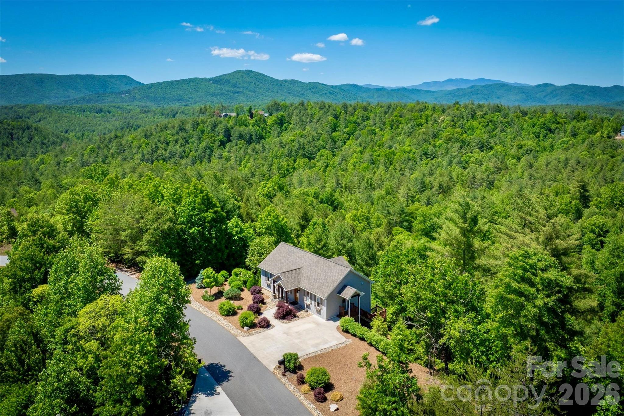 This charming cottage at The Coves Mountain River Club is nestled on 2.5 acres with breath-taking Blue Ridge Mountain views. Table View Lane is a quiet culdesac. This 3 Bedroom 2.5 Bath home is over 2,000 square feet including the finished walkout basement. One level living is also an option as the Primary Bedroom, laundry room, and parking are all on the main level. A gorgeous stone fireplace warms the living room and a wall of windows and full glass doors make the incredible views of Grandfather Mountain, Brown Mountain, and Adams Knob feel so close you can touch them. The back deck feels like your own private tree house with a view! Enjoy your morning coffee or dinner al fresco while taking in mountain air and panoramic views.  The deck is low maintenance, constructed of low maintenance composite deck boards and horizontal steel cables that provide completely unobstructed views.  The kitchen is ready for the chef in the family with a gas range, a large kitchen island with bar seating, and convenient lower cabinets with drawers or pull-out shelves and pull-out trash cans. The green tile backsplash and quartz counters perfectly offset the pecan stained cabinets. The primary bedroom suite has stunning views, walk-in closet, private bathroom with low curb walk-in shower, linen closet, water closet, and double vanities.  The finished basement includes 2 Bedrooms and 1 Bathroom, a den, and a recreation room. An exterior door opens to a back porch and stairs to walk up to the driveway.  Storage space is no problem - there is plenty in the unfinished basement. There is a partial encapsulated crawl space with dehumidification, accessed underneath the lower porch. The Coves Mountain River Club is a 3,200 acre gated community on 5 miles of the Johns River, in the Blue Ridge Mountains of NC. Hike, bike, ride horses, or UTVs on miles of community exclusive trails that weave through your new home. River access areas are ready for you to put in and take out your kayak, wade and fish, picnic, or gather round a stone fire pit. The crown jewel of The Coves is the magnificent post and beam constructed clubhouse, Pisgah Lodge, located on one of the highest peaks. There’s a saline pool, fitness center, locker rooms, full kitchen, lending library, pool table, fire pits, and porches and overlooks to take in 360º views of the Blue Ridge Mountains, South Mtns, and Brushy Mtns. *** The Coves is also a Firewise USA® Community, a program of the National Fire Protection Association, that helps neighbors organize to reduce wildfire risk, harden homes, and create defensible space by managing vegetation and preparing for wildfires.***Garden your private plot at the Community Garden or join your neighbors to care for and harvest the community cooperative vineyard. Pickle-ball and shuffleboard courts, putting green, and a picnic pavilion are located at another Coves's park, Wyatt's Landing. Additional amenities include 2 Equestrian Centers and a Dog Park. A full calendar of events is planned and there are over 30 clubs to join. *** 500,000 acre Pisgah National Forest and the Wilson Creek Wild and Scenic River Area are across the river and road! *** 1.25 hour drive to Charlotte or Asheville, minutes to Lenoir, Blowing Rock, Morganton, and the Blue Ridge Parkway.