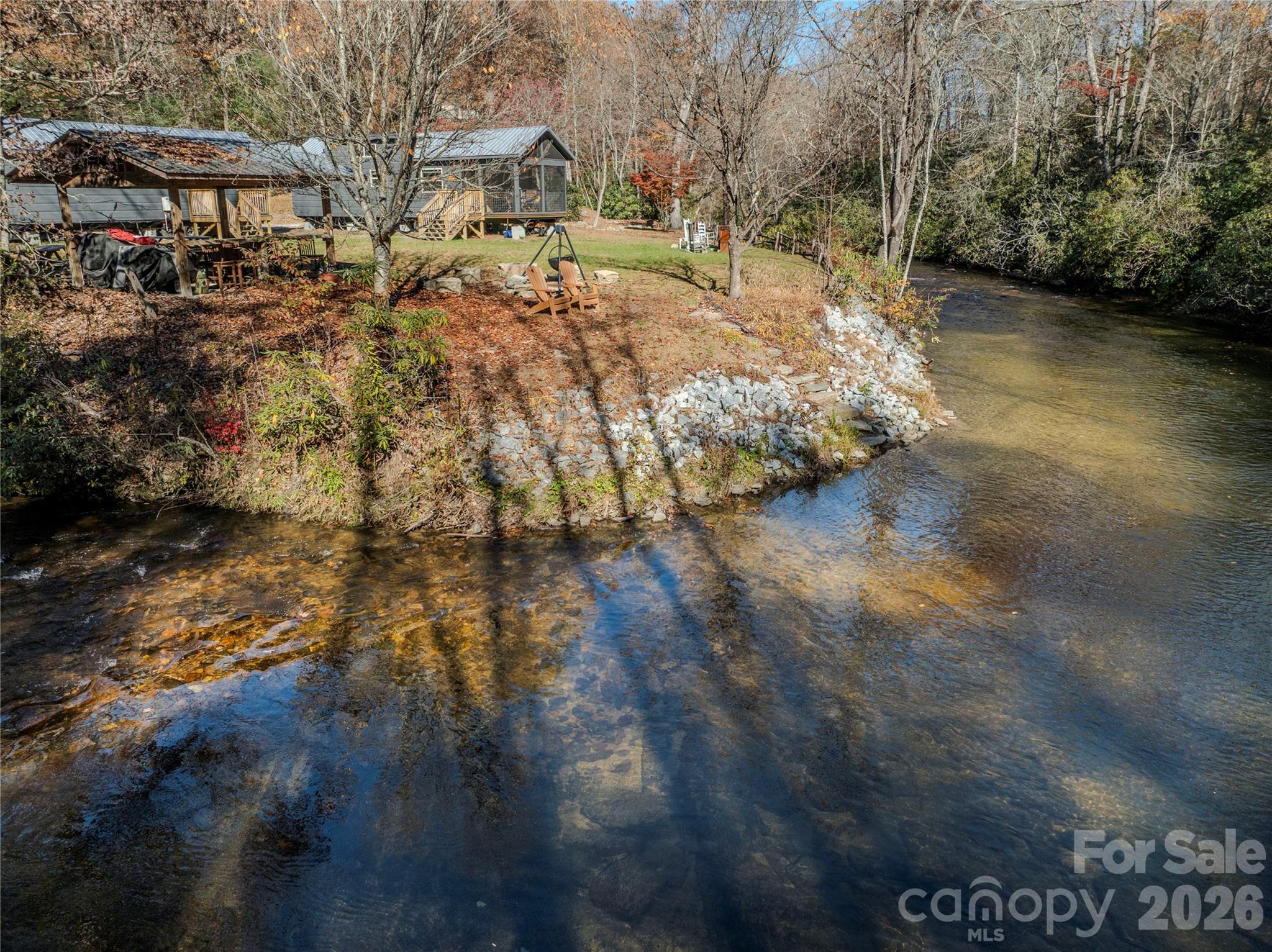 A fly fishing paradise on one of the most beautiful stretches of trout waters in Western North Carolina, this vacation fishing camp is the perfect spot for outdoorsmen looking to spend time on the bold East Fork of the French Broad River - approx. 580 feet of river frontage. The NC Wildlife Resources commission stocks annually over 17,000 brook, rainbow and brown trout along this stretch of delayed harvest designated trout waters. The stream-side cabins sleep six and are comfy and livable, with wood accents, full kitchens and baths, and easy parking. The riverside features an open shed, fire pit, picnic and open lawn areas as well as direct access to the tumbling river. This section of the East Fork is noted for its beauty and fishing, with cascades, runs, pools and holes brimmming with trout. 

Nearby Rosman and Brevard provide shopping, fine dining, live music, art galleries and antique stores, and a vibrant small-town Appalachian culture. Trailheads at Headwaters State Forest are just over 2 miles away to the south, and the vast acreages of Pisgah National Forest are just 5 miles to the north.