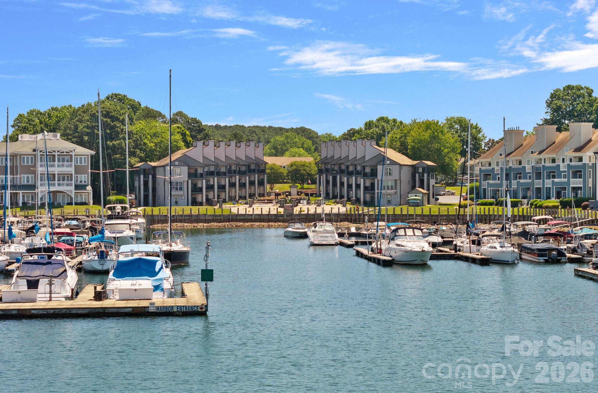 Experience the ultimate lakeside lifestyle in this stunning second-floor waterview condominium located in the desirable Vineyard Point/Dockside community of Cornelius. Perfectly positioned for the most beautiful sunsets! This home offers a rare blend of resort-style amenities and effortless daily living with year-round water access. Residents can enjoy a vacation mindset every day with access to an impressive array of community features, including an outdoor pool on the lake, tennis courts/pickleball, and a scenic lakefront boardwalk for peaceful strolls. The open floor plan is designed for modern comfort, featuring durable vinyl plank and tile flooring throughout, a split bedroom plan for enhanced privacy, and a cozy living room centered around a wood-burning fireplace. The kitchen comes equipped with a breakfast bar, pantry, and granite countertops, while the private covered balcony provides the perfect spot to take in refreshing views of both the pool and the lake. Convenience is paramount here, as the unit includes a laundry closet, storage, and is low maintenance with the HOA handling lawn, landscaping and irrigation. This Vineyard Point gem is the perfect retreat for those seeking both luxury and practicality directly on the water. Access the "Emerald Necklace" of intertwined greenways close by (see attached map), or head to Birkdale Village for dining, shopping and concerts!