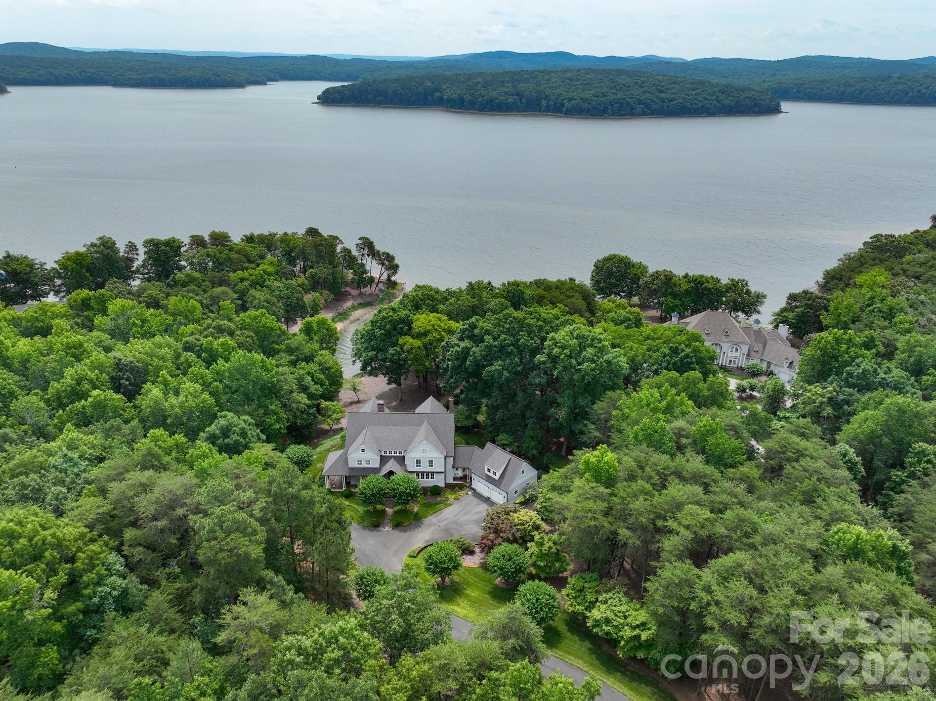 LUXURY LAKE RETREAT WITH PRIVATE PIER! Exhale as you pull onto the wooded private drive to your vacation or primary home at Old North State! Gorgeous light-filled chef’s kitchen with top-of-the-line appliances and no shortage of charm. Take in beautiful lake views from the dining room and living spaces throughout the home. Breathtaking back patio and a shady, winding path down to your own private pier. Elegant primary with its own balcony, en suite bath and spacious walk-in closet. Lovely upstairs bedrooms and en suite baths as well as an airy bonus room with screened porch featuring custom swing beds. Very functional laundry room and lots of storage for water sport equipment and lake toys. Join the Old North State Club to play the championship Tom Fazio golf course, pickleball and tennis, dining, pools, fitness classes and so much more. This extraordinary home is not-to-be-missed!