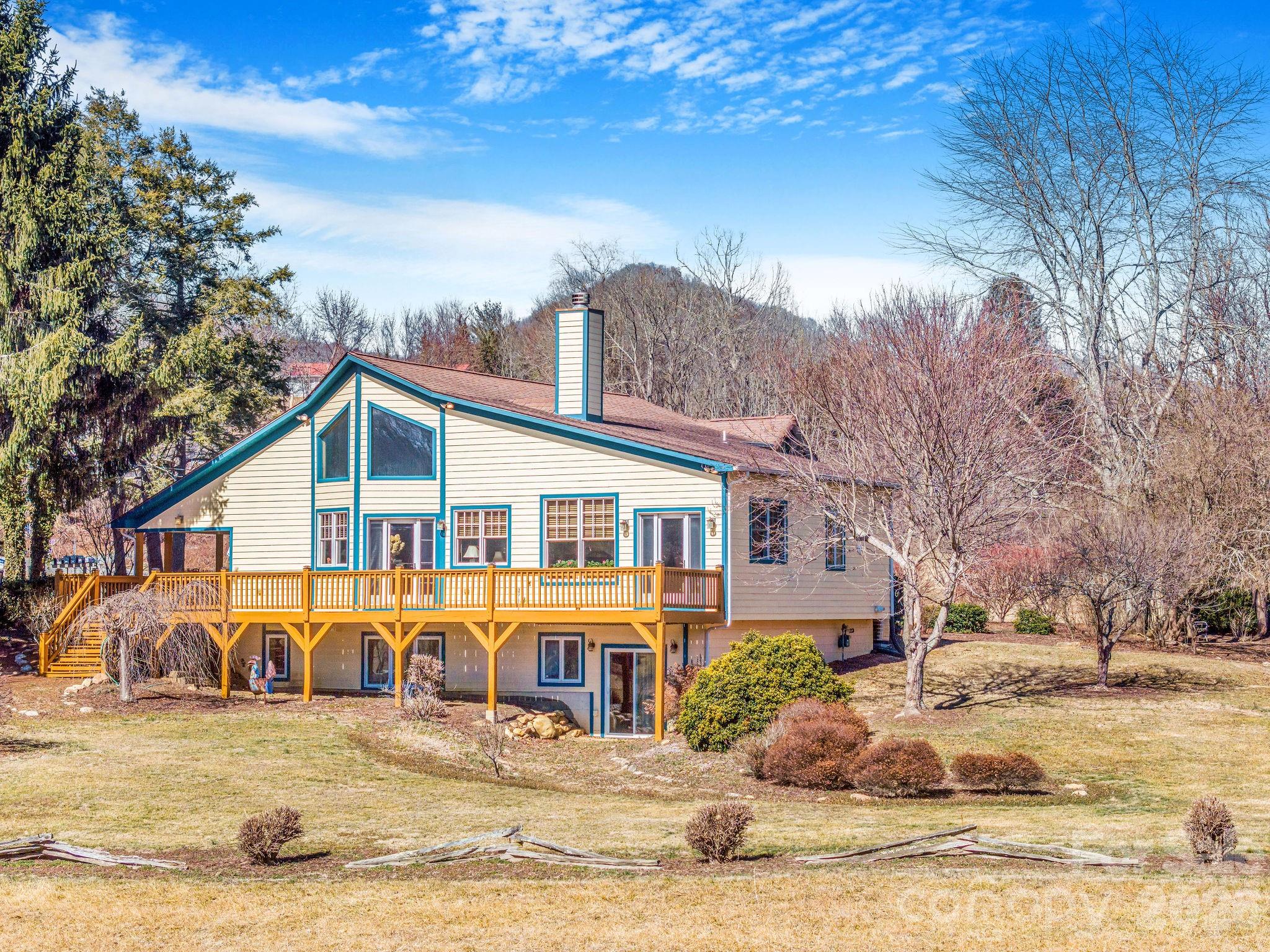 Set on approximately 4.5 private acres in Canton, this thoughtfully expanded 1947 stone cottage offers both convenience and retreat — just minutes to I-40 for easy access to Asheville and Waynesville, yet tucked away in a peaceful natural setting.  Between 2006-2007, the current owners carefully preserved the character of the original 2BR/1BA home while adding over 2,200 square feet of living space, resulting in a spacious 4-bedroom home with office and 3.5 baths (additional 1 bed + 1 bath accounted for in listing is the garage apartment). Original flooring and trim remain in beautiful condition, blending seamlessly with custom finishes throughout.  The main living area features vaulted ceilings, abundant natural light, open dining space, and a striking double-sided wood-burning fireplace shared with the primary suite. The generously sized primary bedroom opens to the expansive front deck, positioned to capture light while maintaining privacy.  The lower level offers a second living area, bedroom, and full bath — ideal for guests, multigenerational living, or flexible use.  Beyond the main residence, the property includes a detached two-car garage with a one-bedroom apartment (tenant in place; lease details available) providing income potential. A two-story barn with tractor storage and workshop space sits alongside pasture areas suitable for a variety of uses.  This unique property offers space, flexibility, and opportunity — a rare combination of privacy, character, and functionality for those seeking more than a traditional neighborhood setting.  

The seller would like to address flood plain concerns with the following statement:
Portions of the 4.5-acre parcel are located within a designated flood plain, primarily affecting the pasture areas. 18 years ago, the residence and improvements were not within the mapped flood zone. Following updated FEMA mapping after major storm events in Haywood County, a small portion of the home’s lower level and garage apartment is now indicated to be within the 500-year flood zone, but not the 100-year flood zone (approximately a few inches at the lowest point). The sellers have enjoyed this property for over 18 years. A nearby culvert has also been replaced with a viaduct, improving water flow beneath I-40. Buyers are encouraged to review all available information and verify to their satisfaction.