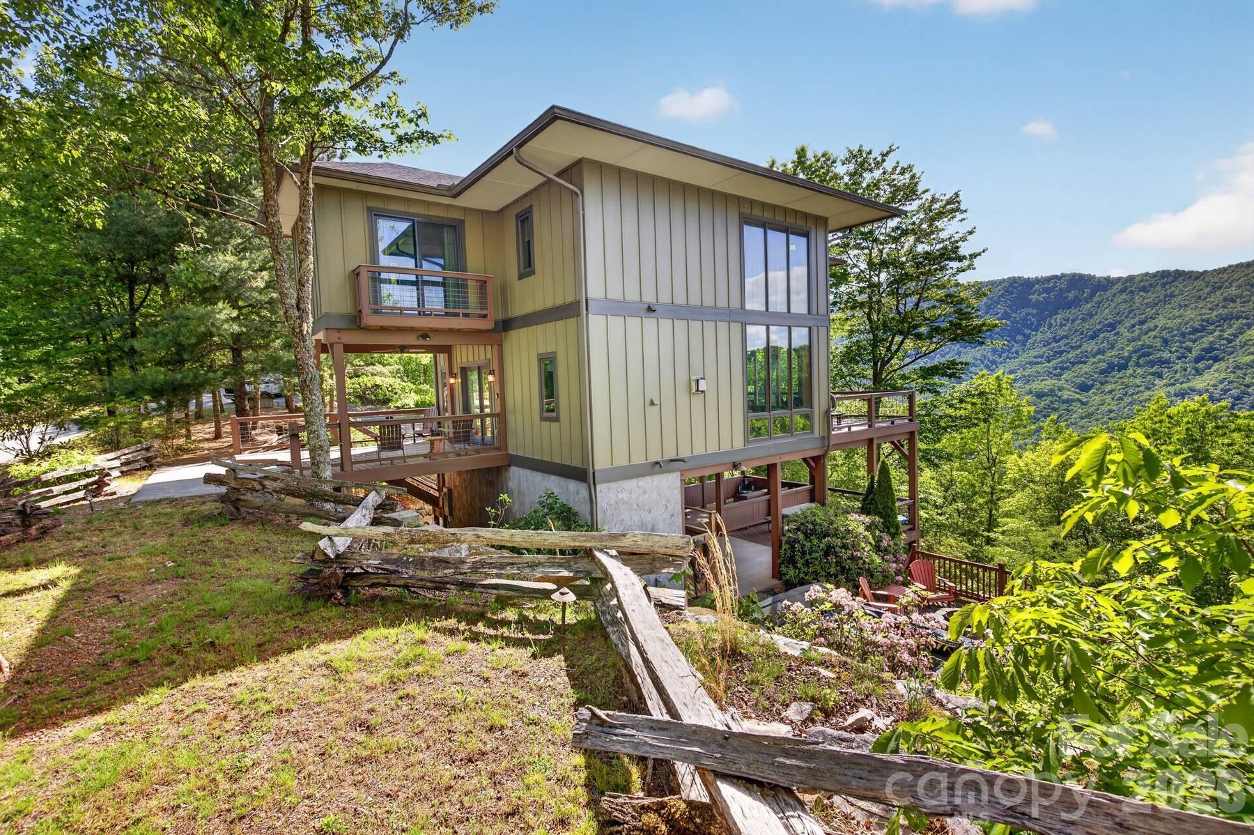 Experience modern mountain living in this stunning home perched above Fontana Lake in the heart of the Smokies. Walls of windows flood the open-concept living space with natural light and frame breathtaking sunrise views over the lake and sweeping northwestern vistas into the national park—views you can’t escape from any room in the house. With 2 bedrooms, 2.5 baths, and a spacious loft, this thoughtfully designed retreat comfortably accommodates family and guests. The home is fully furnished with upscale furniture and features a brand-new Catalina luxury hot tub for relaxing after a day of adventure. Entertain with ease on the incredible covered lower terrace, complete with a firepit, hot tub, and plenty of room for gatherings, and 2 storage rooms. Additional features include an EV charger and an outdoor shower for a true mountain experience. Located in Rockledge, a gated community on Fontana Lake, you’ll enjoy exceptional amenities such as lake access, boat slips, a picnic area, hiking trails, a pavilion with a fitness center, and a kids' play area. The property boasts 3.659 acres and the flexibility to expand—Easy access to Bryson City and located just minutes to the NOC!