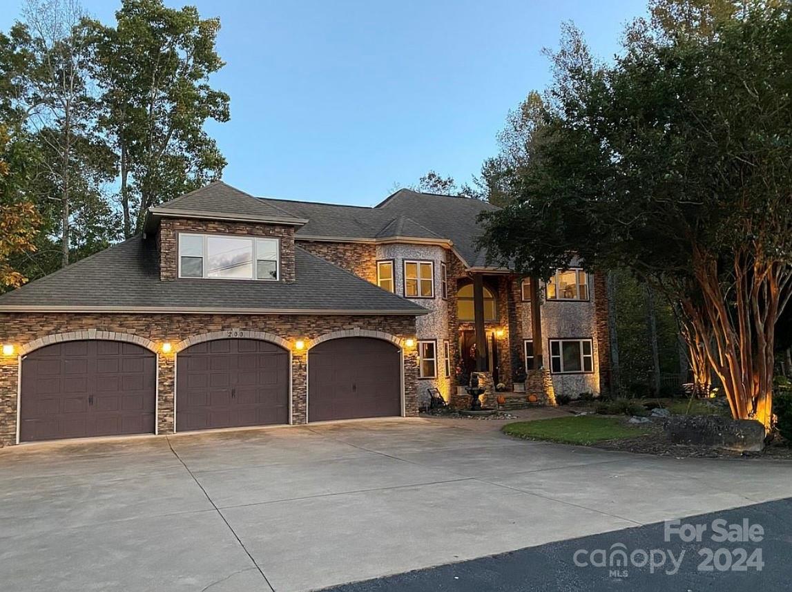 Beautiful lakefront home with long range & golf course views, located on tee box #12 of Marion Lake Club. Mountain views out the front of the house & a quiet cove with private dock with flagstone fire pit sitting area at the rear. Spacious kitchen with large island, granite counter tops & stainless steel appliances. 2 primary suites; one on main & one on upper level. 2 additional rooms with private baths on upper level. 2nd level also includes a bonus room over the garage, currently used as sitting room with an electric fireplace and 2 closets. Upper and main level laundry rooms. Hardwood floors throughout with tiled baths. Finished basement includes additional room, full bath, large family room, and full kitchen. Tons of storage space. 3 car garage. Partially covered deck with outdoor kitchen. Large workshop/shed located along the lower patio, with paved driveway connection. Paved golf cart path and stairs lead down to the lake w/ covered dock. Dock has HydraHoist boat lift.