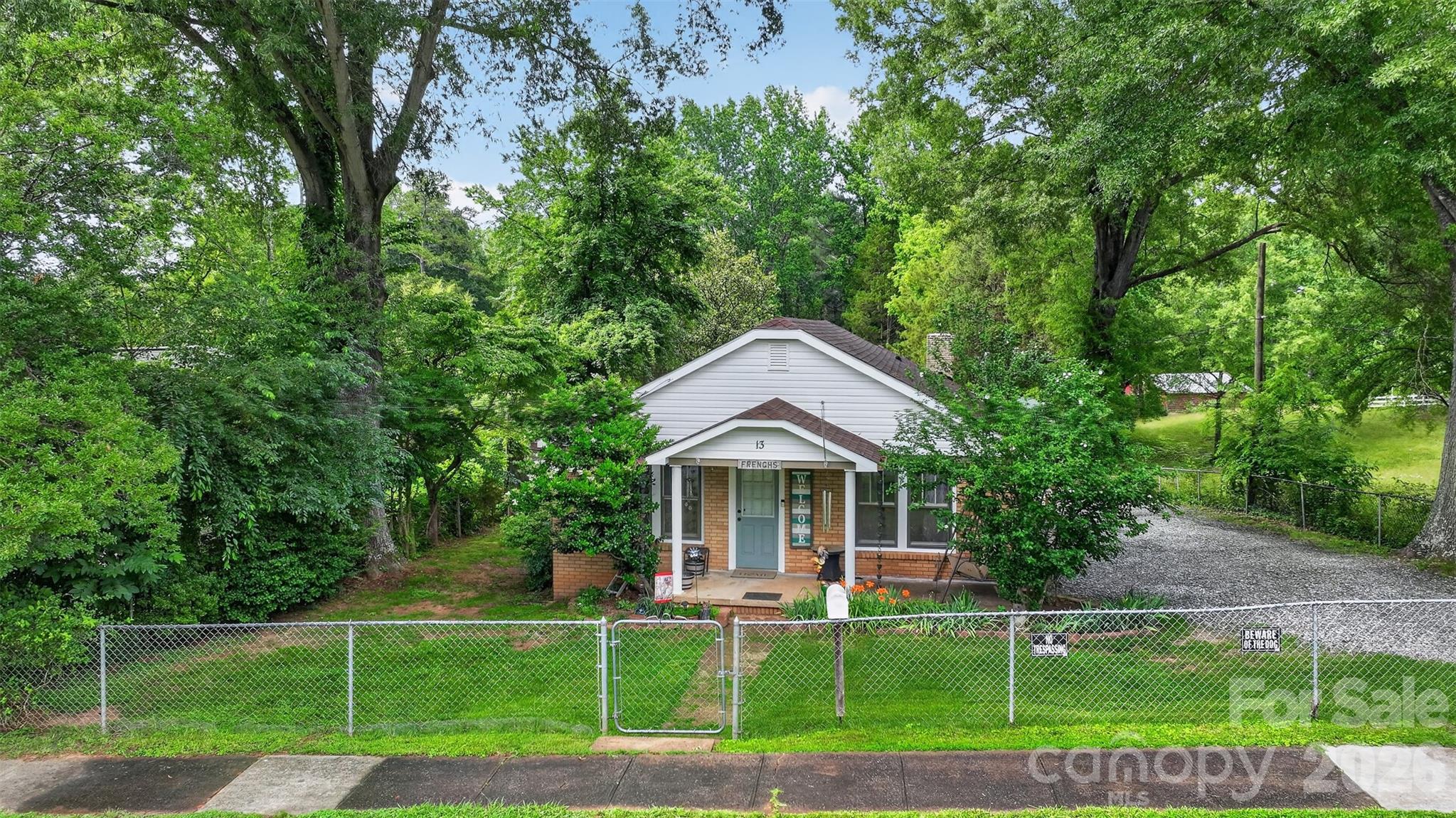 Located on a peaceful side street on the edge of Maiden, this inviting three-bedroom, one-bath home offers the perfect balance of privacy and convenient access to downtown. Set on nearly one acre, the property provides space and tranquility while remaining just minutes from restaurants, schools, and local amenities.

The well-maintained single-level home features an open main living area with multiple bedrooms opening directly off of it. The updated kitchen showcases fresh cabinetry, and laundry hookups are conveniently located on the main level. A beautifully updated full bath with an expansive shower is centrally located for easy access from all bedrooms. The walk-out basement offers additional flexible space.

Outside, a spacious above-ground pool is surrounded by a large wraparound deck that offers both privacy and generous space for lounging and relaxing in the sun. A fire pit creates the perfect setting for evening gatherings, while mature trees and walking trails wind through the back portion of the lot. The front half of the property is fully fenced, providing both a secure space for pets and added privacy, with a gate leading to the wooded trails in the back half of the lot. Additional features include a detached two-car garage, a separate storage shed, and plenty of parking on the gravel driveway.

This charming home welcomes you to experience its peaceful setting and thoughtful layout. Come see for yourself all that this special property has to offer.