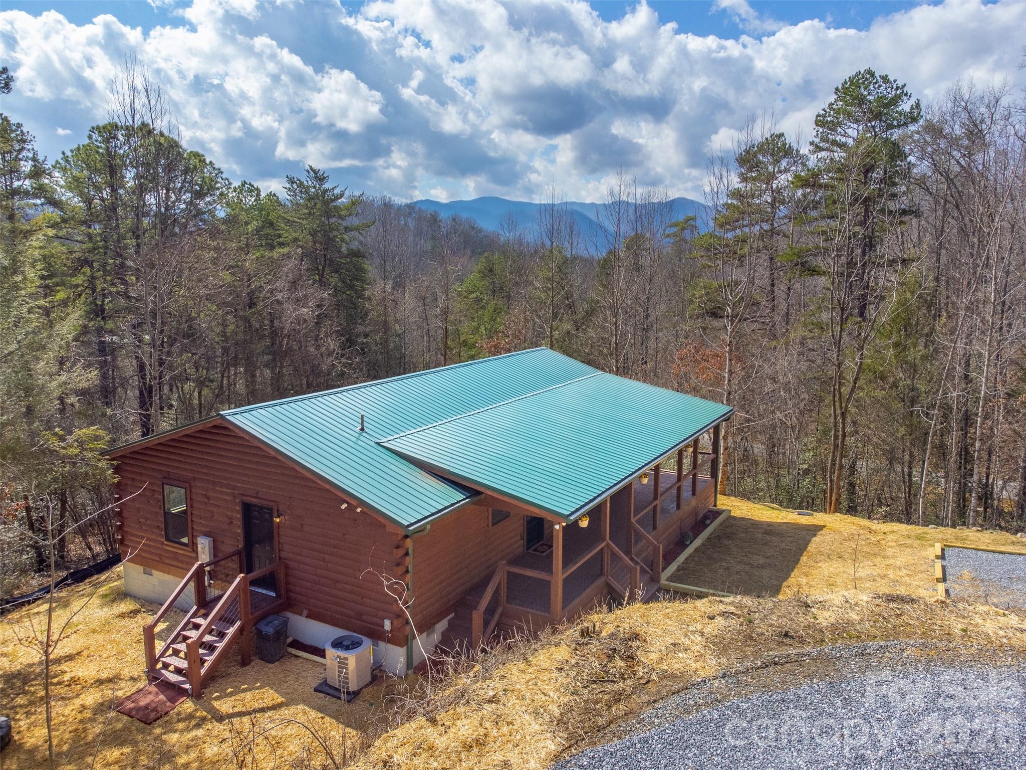 Welcome to this charming brand-new 2-bedroom, 2-bath log cabin that blends rustic warmth with modern comfort. The open living and kitchen area features vaulted tongue-and-groove ceilings, butcher-block countertops, stainless steel appliances, generous cabinet and counter space, and an island with a breakfast bar that connects easily to the dining area. A cozy corner stacked-stone gas fireplace anchors the living room, creating the perfect spot for cool mountain nights. The spacious primary suite offers a vaulted ceiling, dual-granite vanity bath, and private access to the wraparound covered porch. A guest bedroom, second bath, and a large laundry/storage room with a gas tankless water heater complete the interior, all enhanced by durable luxury vinyl plank flooring. Outside, enjoy a low-maintenance exterior with a metal roof, seasonal winter mountain views with summer privacy, ample parking, and a dedicated firepit area. Located in a gated log cabin community with sensible restrictions and paved roads, this home offers peace of mind and convenience. Just minutes from Harrah’s Cherokee Casino, it’s ideal as a vacation rental, second home, or full-time getaway.