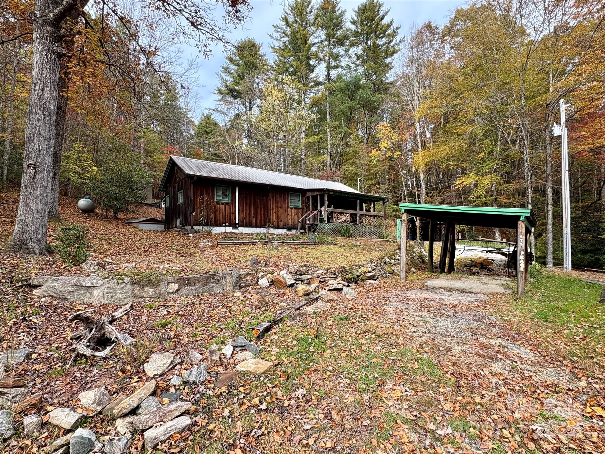 Quaint cabin nestled by the sound of running water. This property calls you home! 2BD 2BA with a bonus room/office space. In addition to the mini-split system and propane, the woodstove will top off those chilly mornings. Private and unrestricted on more than 1.5 acres with a small pond adjacent to the home. Plenty of storage with one outbuilding and another that could be a workshop. Two carport areas for ample covered parking. It's rare to find an authentic cabin like this in such a beautiful, peaceful yet convenient area. Only 15 minutes to the heart of Brevard. Truly a must see!