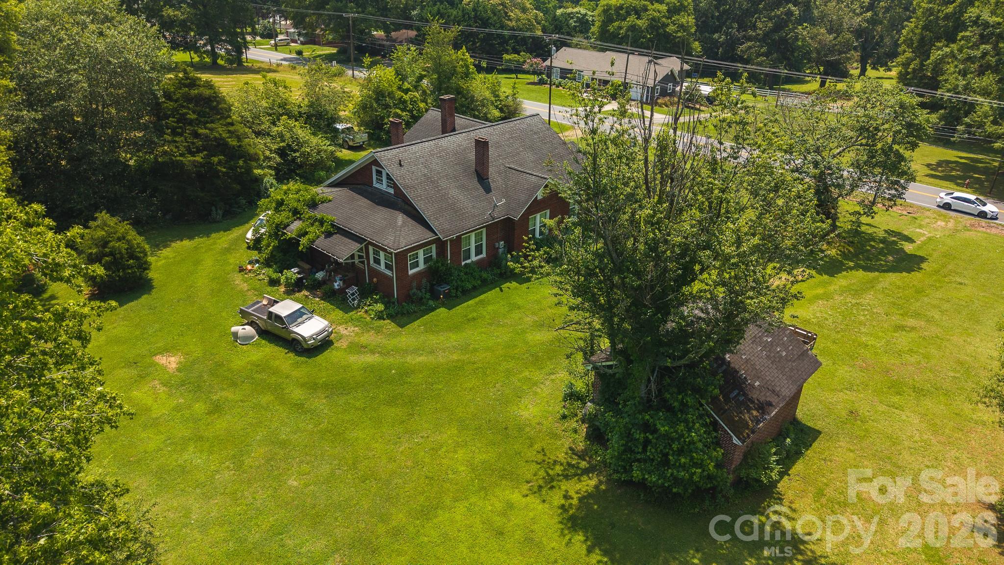 1040 NC Highway 90 W | Taylorsville, NC 28681

Discover the charm and potential of this beautiful 1940s farmstead situated just outside the Taylorsville city limits. Offering over 16 acres of gently rolling land with long-range mountain views, this unique property blends timeless rural character with exceptional future possibilities.

With approximately 450 feet of frontage along NC Highway 90 and additional access from Gravel Hill Road, the property offers outstanding accessibility and visibility. The picturesque acreage features open land, mature trees, and multiple potential homesites, making it well-suited for a private estate, family farm, residential development opportunity, or limited agricultural use.

The property includes a charming 3-bedroom, 1-bath farmhouse built in 1940 featuring two covered porches, an unfinished basement, unfinished upper level, and a detached two-car masonry garage. Rich in character and country appeal, the home is currently tenant occupied and used as a rental, offering opportunities for continued rental income, renovation, or restoration into a showcase country residence.

Located within the ETJ (Extra-Territorial Jurisdiction) and currently zoned R-1, the property is subject to both Town of Taylorsville and Alexander County zoning regulations. R-1 zoning does not allow manufactured homes, but does permit a variety of additional uses including schools, libraries, and nonprofit recreational facilities such as community centers and swimming pools. Buyers are encouraged to verify permitted uses, zoning regulations, and future development possibilities with Alexander County Planning & Development.

Conveniently positioned bordering the Taylorsville city limits, this property offers the rare combination of acreage, road frontage, mountain views, vintage farmhouse appeal, and future investment potential.