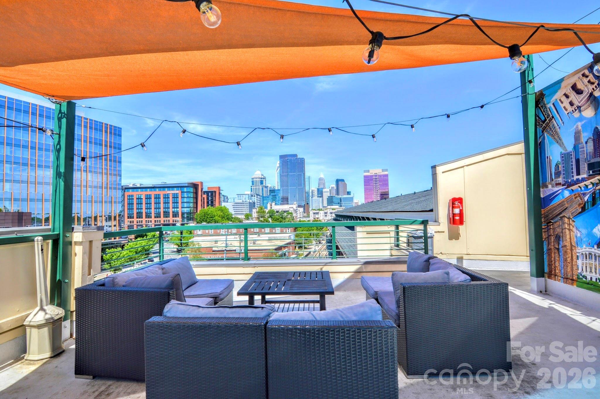 The ULTIMATE South End location! Just steps from the Rail Trail and some of Charlotte’s most popular restaurants and nightlife, this top-floor 1-bedroom, 1-bath condo offers the perfect blend of convenience and privacy.  Located on the 4th floor with easy access from the parking garage, this freshly updated unit features soaring ceilings and dramatic floor-to-ceiling windows that flood the space with natural light. The open-concept living area flows seamlessly into the kitchen, complete with wood cabinetry, stainless steel appliances, and a breakfast bar with stone countertops.  Enjoy your morning coffee or unwind in the evening on the private balcony overlooking vibrant South End activity.  The main level includes a welcoming foyer with a convenient storage closet, a laundry closet with brand new GE stackable washer and dryer, and a beautifully updated full bathroom featuring tile flooring, a stone countertop, a fresh vanity, and a modern backlit LED mirror.  Upstairs, the lofted bedroom offers a spacious built-in closet system designed for maximum organization.  Residents also enjoy access to a stunning rooftop terrace with unbeatable Uptown views—perfect for entertaining, working remotely, or simply relaxing.  Freshly painted and brand new flooring throughout, this move-in ready condo is a rare opportunity in one of Charlotte’s most sought-after locations. Don’t miss your chance at this great condo to work and live!