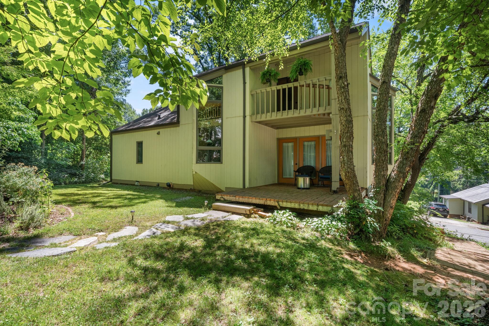 Designed by local architect Folger Architecture, the mid-century details in this downtown Morganton home make it a refreshing departure from cookie cutter construction. This home is located on one of downtown Morganton's most popular thoroughfares - providing the perfect location to walk or bike to downtown Morganton. Enjoy shopping, dining, concerts, and community events. Step inside off one of several covered decks into the dining room. A functional size for dining and using as the hub of the house. Off the dining room is the kitchen where the details continue. Thoughtfully designed to complement the home's architecture, the kitchen features clean lines, warm wood finishes, dramatic floor-to-ceiling windows, and period-inspired lighting that celebrates the home's original character. Two of the home's four bedrooms are located on the main level in addition to a full bathroom. The living room on the main floor is one of two dedicated living spaces in the home and features a gas fireplace. Step out from the living room into the sunroom and then onto the uncovered back deck. Upstairs you'll walk into the second living room where the attention to detail continues. This living room is centrally located between two large bedrooms. One bedroom has a Juliet balcony and the other a private covered deck. Upstairs also offers a huge walk in closet and a full bathroom. Need extra storage? The unfinished basement provides plenty of room for everything from holiday décor to outdoor gear. There is also a finished office in the basement that isn't included in the heated square footage but is the perfect spot to work, create, or play in a home office or studio. The basement office also has a separate exterior entrance. There is also a half bathroom in the basement. A rare opportunity to own a home where thoughtful architecture, timeless design, and an unbeatable downtown location come together!