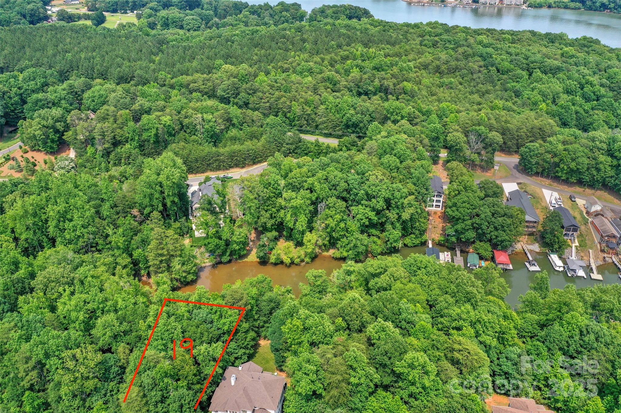 Build your dream custom walkout basement home on this prime .4-acre waterfront lot located in the prestigious Reflection Pointe gated community in Belmont, North Carolina. This rare property offers private kayak and paddleboard access within a serene cove on Lake Wylie, providing a seamless connection to the water. Perfectly positioned for commuters, the lot is just 20 minutes from Charlotte Douglas International Airport and 30 minutes from Uptown Charlotte. As a resident of Reflection Pointe, you will enjoy resort-style amenities including a clubhouse, swimming pool, tennis and pickleball courts, paved walking trails, a soccer field, and a waterfront pavilion with a marina and community beach. The property is minutes from historic downtown Belmont, a destination known for its craft breweries, local restaurants, and retail boutiques. This build-to-suit lot allows for featured community builders or your own qualified custom builder, provided they meet the community’s architectural guidelines. Minimum construction requirements are 2,000 HLA  for a 1-story home and 2,400 HLA for a 2-story residence.