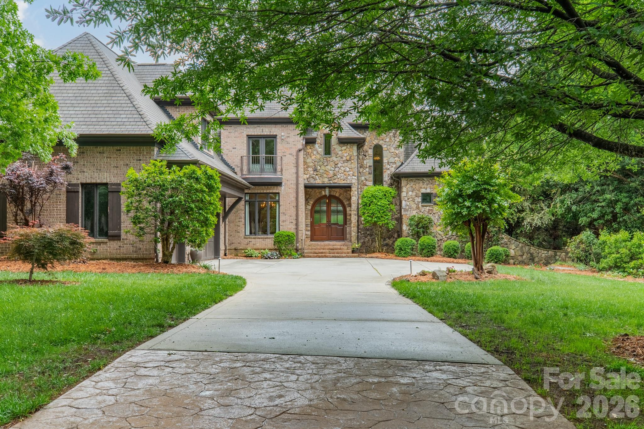 Located in the exclusive gated community of Chatelaine, this full brick custom home offers refined living with exceptional space, craftsmanship, and views. Double curved mahogany doors set the stage for this custom home, showcasing quality construction with rounded wall corners, real wood floors, oversized rooms, heavy trim, fresh paint, and all-new carpet. The main level features an open, functional layout ideal for both everyday living and entertaining. The grand foyer overlooks the formal living room with a coffered ceiling, large windows that bring in an abundance of natural light, and a see-through gas fireplace. The high-end chef’s kitchen is well-appointed with Viking appliances, including a gas cooktop with grill, wall oven, microwave, and dishwasher, complemented by a 48” Sub-Zero refrigerator, granite countertops, and a center island with prep-sink. The kitchen flows seamlessly into the breakfast area and spacious great room with a fireplace, all with direct access to the rear deck overlooking the backyard and community pond. A formal dining room connects to the kitchen via a butler’s pantry for added convenience. The oversized main-level primary suite with tray ceiling offers privacy and comfort, while the spa-like bath with dual vanities, whirlpool tub, and tiled shower provides a relaxing retreat. The walk-in closet features custom built-ins. A well-placed laundry room with sink and a drop zone is located off the oversized three-car garage—complete with a separate storage room which enhances everyday functionality. Dual staircases lead to a versatile upper level featuring a bedroom with an ensuite bath, two additional bedrooms connected by a Jack-and-Jill bath, a loft area, and a flex room with walk-in attic access—ideal for an office, playroom, or quiet space. A large billiard room includes access to a powder room for guests. The media/theater room is equipped for movie nights and entertainment with a screen, speakers, equipment, and a wet bar. Outdoor living is highlighted by a private backyard with direct pond and fountain views, along with landscape lighting—an ideal setting for entertaining. Zoned for top-rated Weddington schools, this home combines timeless design, thoughtful layout, and a premier location.  Don’t miss out on this beautiful and functional home.  Make your appointment Today!