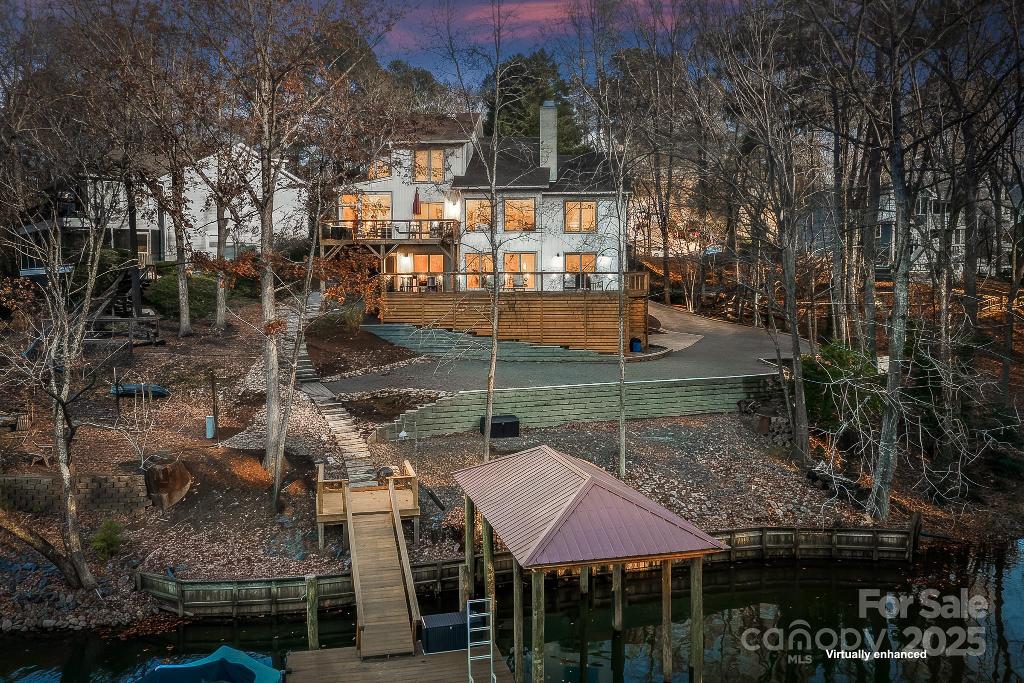 Discover your dream WATERFRONT contemporary home in the heart of Tega Cay! This stunning home offers 5 bedrooms and 4 full baths and 2 ½ baths. There are two 2-car garages and a HUGE driveway and 4 dedicated parking spaces in front. The 2 story Great Room features a wood burning fireplace overlooking the view of the lake. There is a screened in porch off the Kitchen/Dining Room. Primary Bedroom on Main level has an ensuite and 2 walk in closets. Lower level has 2 Bedrooms plus Den & a kitchenette. Low maintenance floating dock with covered boat storage. Peaceful lot located on a protected deep water cove just off the main channel on Torrence Creek with 147' of shoreline. This home could work for Multi-Generational living or rental. Just over the border from Charlotte, NC. Top ranked Fort Mill Schools. Enjoy the recreational lake city of Tega Cay. Waterfront parks, boat ramps, beaches, sport courts, pickleball, tennis, Tega Cay Golf Club, Tega Cay Beach & Swim Club, walking trails, & more.  New Roof, windows, doors, paint, flooring, decks were expanded with a screen porch addition in 2020.  New covered boat dock in 2022.  Too many renovations and upgrades to list!  This is a MUST SEE!