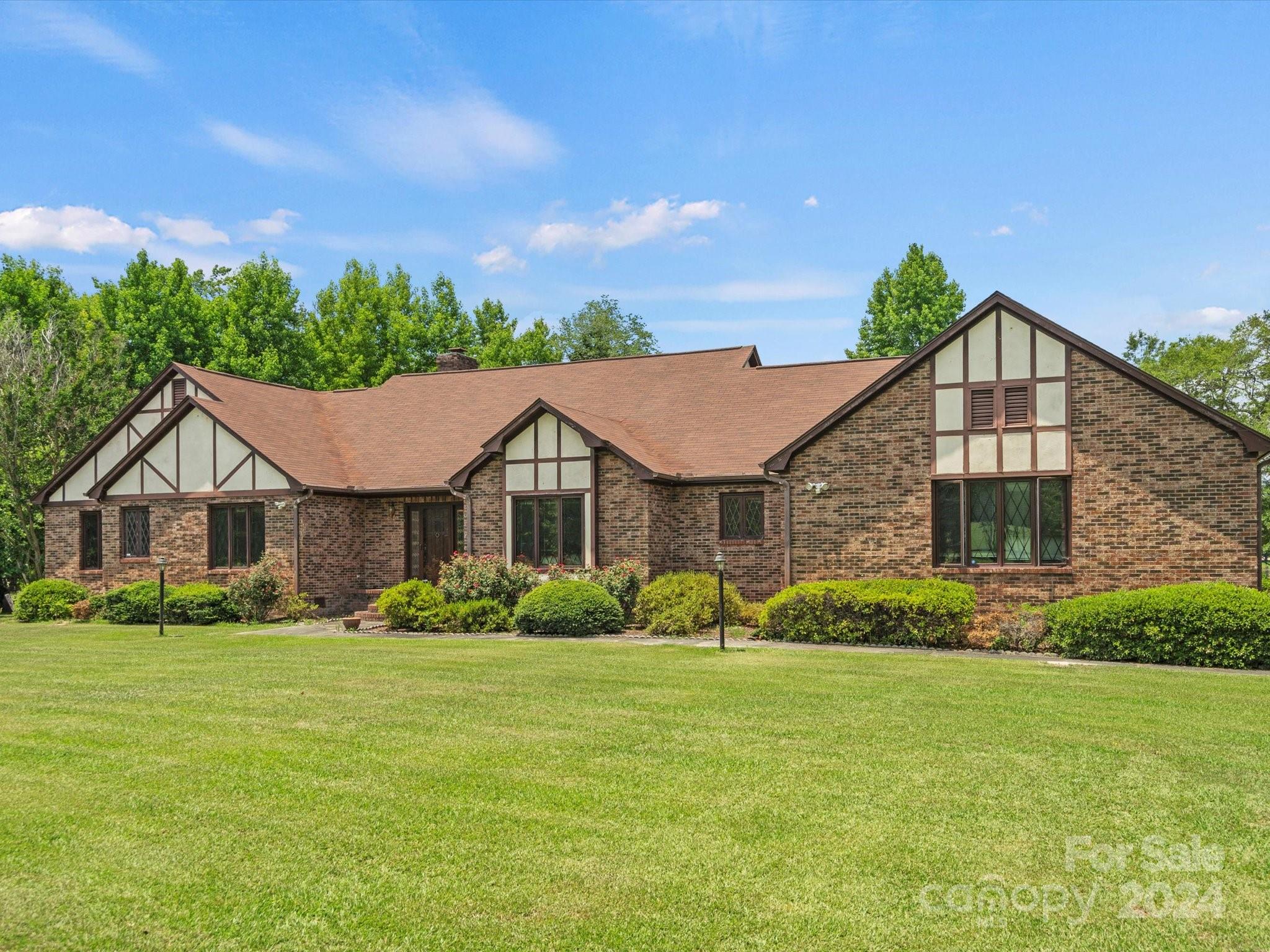 Country living at its finest! This wonderfully built, well-maintained 3BR/2.5BA has a pond view and sits on just over five acres of land. The space is here is fantastic! The front, brick foyer leads to the large den with wooden beams, which then opens to the dining area. Just next to it is the generous sized kitchen with plenty of room to "eat-in." Also, there is a separate laundry room, additional 1/2 bath, great storage, and lots of natural light throughout the home. The screened in porch on the side has panels which can be put in, making it suitable to enjoy in multiple seasons. Two brick porches on the back, a deck area looking over the pond, a small bridge and arbor (which both lead to the side yard), and a great shop for working or storage. The electric gate and long, paved driveway are both big pluses, as well. In addition to parking space, the garage has a lift for a wheelchair. So much to take in! Make an appointment to see this one soon!