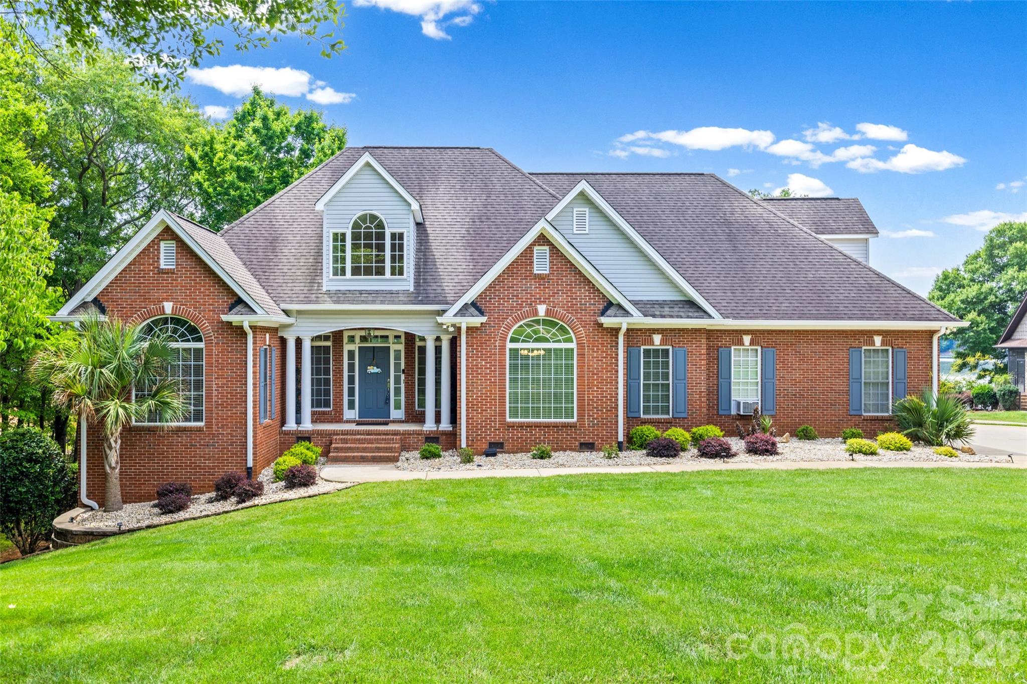 Welcome to the lakefront lifestyle your family has been dreaming of at 1850 Poinciana Drive. Nestled on the shores of Lake Wylie within the award-winning Clover School District, this custom-built brick ranch offers breathtaking long-range water views, exceptional living spaces, and the perfect setting to create lifelong memories. Best of all, there is no HOA, giving you the freedom and flexibility to truly enjoy your waterfront property without additional restrictions or fees.Designed with both everyday comfort and entertaining in mind, this thoughtfully crafted home offers over 3,291 square feet of living space, including a private lower-level retreat with its own entrance and full bath—ideal for a home office, fitness studio, media room, or guest accommodations.The bright and inviting great room features soaring vaulted ceilings, rich hardwood floors, and a cozy gas fireplace, all opening seamlessly to an expansive screened porch where you'll enjoy morning coffee, family dinners, and spectacular sunsets over the lake. The well-appointed chef's kitchen is the heart of the home, complete with granite countertops, double ovens, a breakfast bar, and a sunny breakfast area perfect for busy school mornings.Wake up each day to serene lake views from the spacious main-level owner's retreat, featuring a sitting area, tray ceiling, and a beautifully renovated spa-inspired bath with dual vanities, a walk-in tiled shower, and a relaxing garden tub. Upstairs, a generously sized bedroom or bonus room with a full bath provides flexible space for a playroom, teen suite, or additional guest accommodations.Outside, the opportunities for family fun are endless. The beautifully landscaped yard offers multiple spaces to gather and unwind, including a large deck, screened porch, patio, and a private floating dock with a seating area. Spend your days boating, fishing, swimming, paddleboarding, or simply soaking in the peaceful beauty of Lake Wylie right from your own backyard.Complete with an oversized two-car garage, low South Carolina taxes, no HOA, and access to the highly sought-after Clover Schools, this exceptional waterfront home combines the tranquility of lake living with the convenience and freedom today's families desire.Come experience why life is simply better on Lake Wylie.