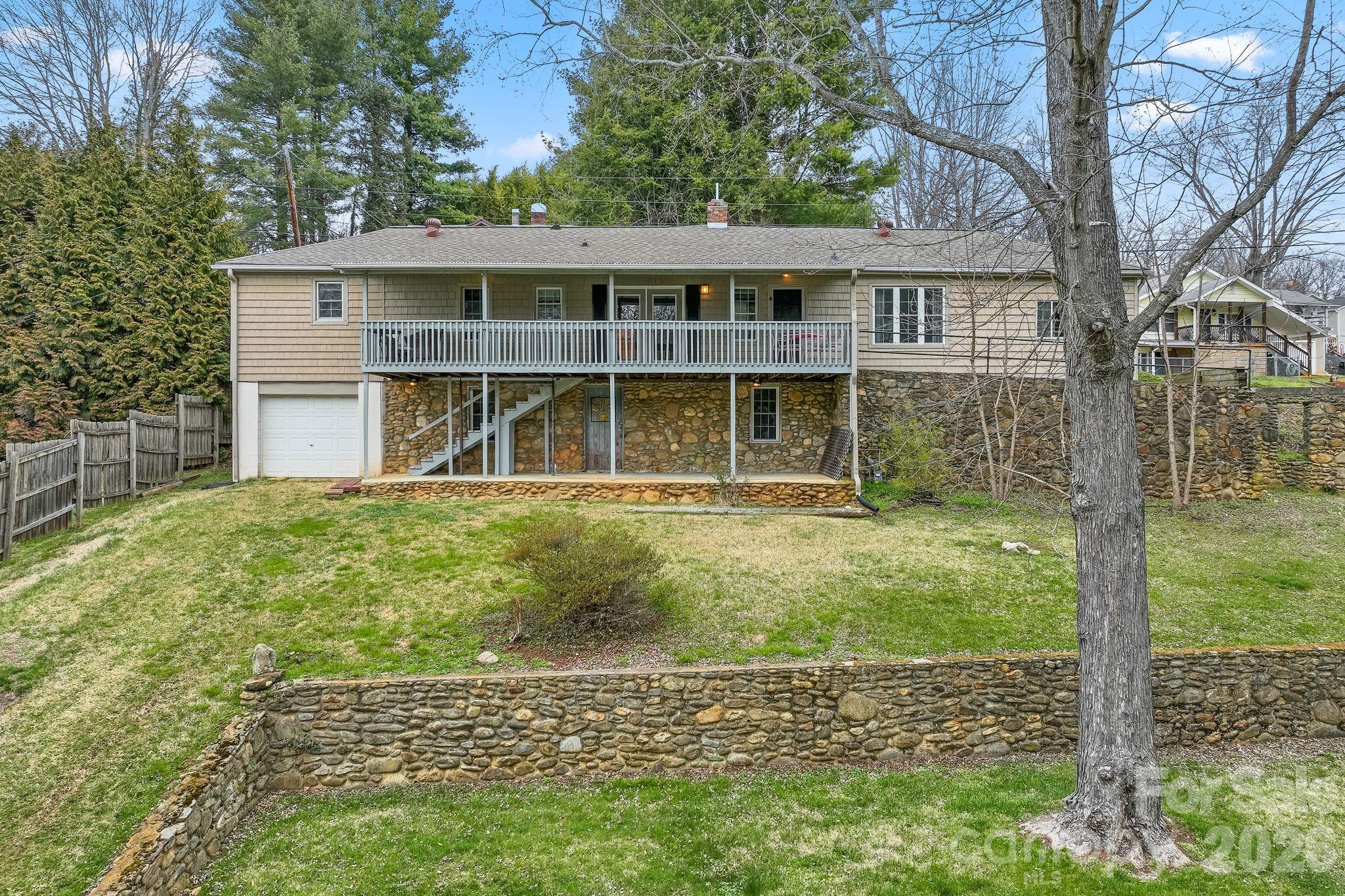 Conveniently located approximately 20 minutes from both Asheville and Waynesville, this property offers a peaceful setting with mountain views and easy access to area amenities. The home sits on a spacious lot with a private deck overlooking Pharr Branch, creating a relaxing outdoor environment ideal for enjoying the natural surroundings.

The Johnson Street side of the property experiences minimal through traffic, enhancing the sense of privacy. The yard and creek area provide a pleasant setting for outdoor activities, including walking pets.

The home features a distinctive stone foundation and includes two attached single-car garages, offering flexibility for parking, storage, or workshop space.

Located near downtown Canton, the property offers convenient access to local restaurants, retail venues, and ongoing community revitalization.

Property is being sold as-is. Buyer is encouraged to conduct all inspections and due diligence. Relevant reports, survey, and additional property information are available for review.