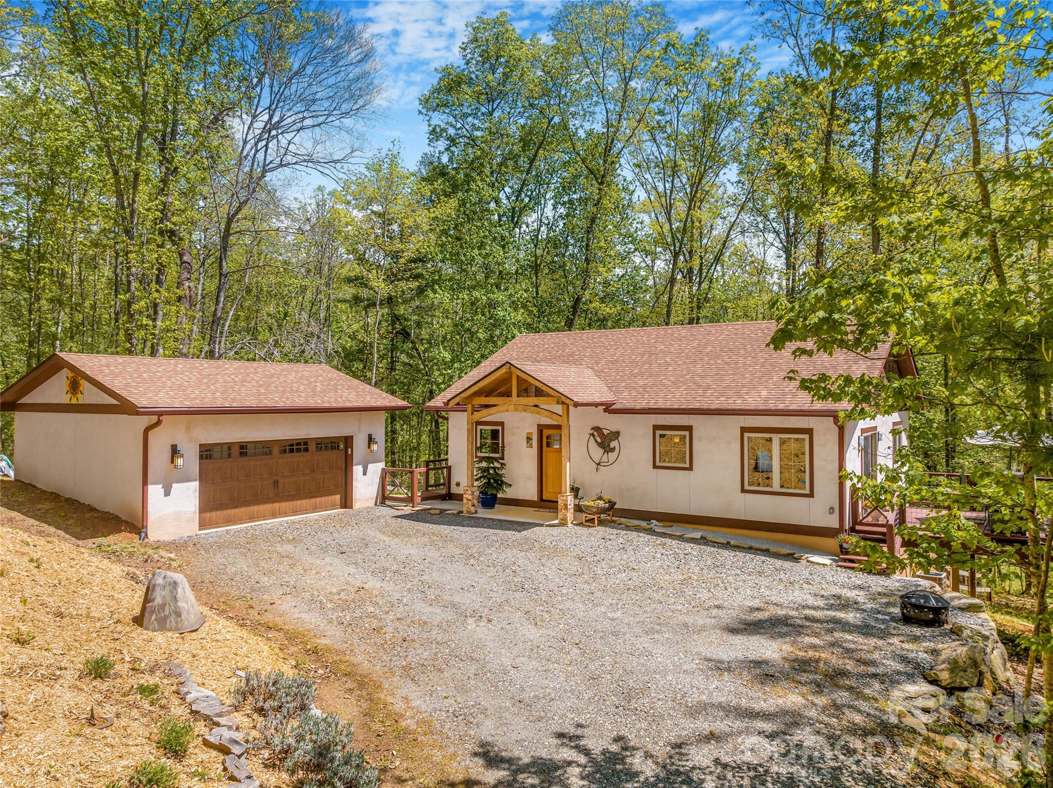 Open House 6/14, 2-4 PM! Welcome to a rare opportunity in Mountain Meadows—an intentional community where connection, nature, and mindful living come together seamlessly. 

446 Amanda Drive is a thoughtfully designed green-built home that blends artistic craftsmanship with everyday functionality—and is proudly certified at the Silver level by the Green Built Alliance, reflecting a commitment to energy efficiency, sustainability, and healthier living.

Flooded with natural light from abundant windows, the home feels alive—warm, inviting, and deeply reflective of its natural surroundings.

Inside, you’ll find luxury vinyl plank flooring, wood trim, and custom artistic tile work that adds character and originality throughout. At the heart of the home, a soapstone wood-burning stove creates a cozy, grounding focal point—perfect for crisp mountain mornings and relaxed evenings.

The layout offers the potential for one-level living for comfort and peace of mind. While the home is permitted for a 2-bedroom septic, it lives expansively thanks to multiple flexible bonus spaces on the lower level—perfect for a home office, recreation room, art studio, or even an additional kitchen.

Step outside and experience true mountain tranquility. Garden in the established beds in your yard, take a stroll through the neighborhood or simply relax and enjoy the sounds of nature. The end of the road location offers the feel of a private retreat while remaining incredibly convenient: just 10 minutes to downtown Mars Hill and about 20 minutes to Weaverville, Marshall, or Burnsville.

The detached 2-car garage is a standout feature—complete with a separate 220 outlet currently used for a kiln, making it an ideal workshop, studio, or storage space.

Pet lovers will appreciate the fenced yard area and mudroom dog door for easy indoor-outdoor living. Additionally, the community pavilion is a great place for social gatherings and shared growth in the organic community gardens. 

This is more than a home—it’s a lifestyle designed for ease, creativity, and connection.