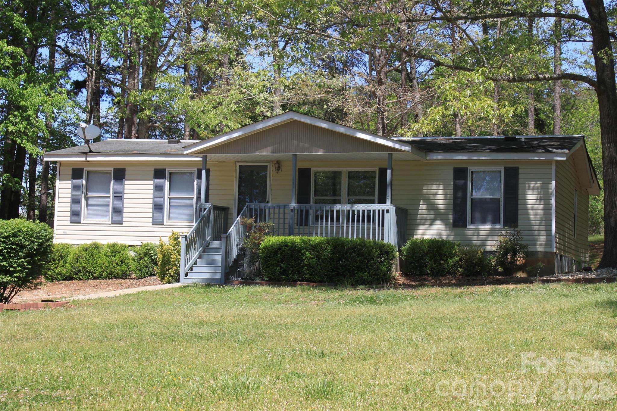 3BR/2BA manufactured home on 0.94-acre lot in rural Mooresboro offering privacy and space. Built in 1993 with 1,056 sf, this property features a functional single-level layout with main level bedrooms and in-hall laundry. Kitchen includes electric range, microwave, dishwasher, refrigerator, and self-cleaning oven. Covered front porch, rear deck, and screened porch provide multiple outdoor living options overlooking a spacious yard. Publicly maintained paved road access. Well and septic in place. Heating and cooling via electric heat pump with ceiling fans. Crawl space foundation. No HOA.  Convenient access to surrounding areas while maintaining a quiet setting. An additional 128 sf of the home has been added and has not been permitted ( not counted in original sf count on listing). The outbuilding includes a 400 sf additional dwelling unit that is not permitted and has a storage unit attached.