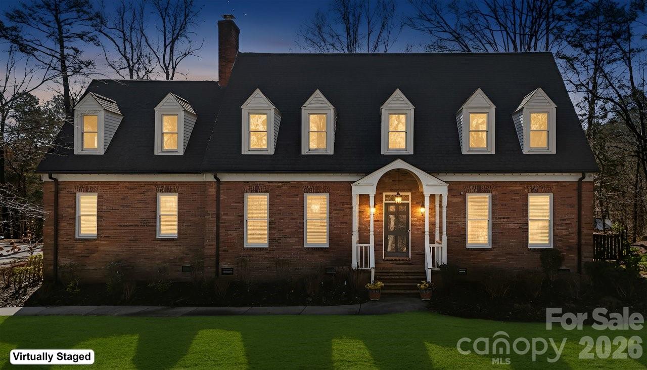 Tucked on nearly three tree-lined acres, this stately two-story brick home delivers the rare combination buyers dream about — estate-level privacy with quick access to town, schools, shopping, and major routes.
Step inside and you’ll find a main-level primary suite designed as a true retreat, complete with a spacious en-suite bath. The updated gourmet kitchen flows effortlessly into a sun-drenched sunroom — the warm, welcoming heart of the home. Just beyond, a bi-level deck with built-in grill invites you to entertain, unwind, and soak in peaceful wooded views.

Upstairs, three oversized bedrooms and two full baths offer plenty of room for family and guests. A dedicated media room with full theater setup, plus expansive bonus and flex rooms with a mini kitchen, mean there’s space for movie nights, hobbies, a home office, or multigenerational living.
Rich hardwood floors run throughout, and thoughtful design delivers storage galore — abundant closets, built-ins, and well-planned utility areas at every turn. A convenient side-entry two-car garage with drop zone keeps daily life organized.

Outside, beautifully landscaped grounds come alive each spring with dahlias, primroses, knockout roses, rose trees, daffodils, and hostas — your own private garden retreat just minutes from it all.
Acreage. Privacy. Convenience. This one truly has it all.