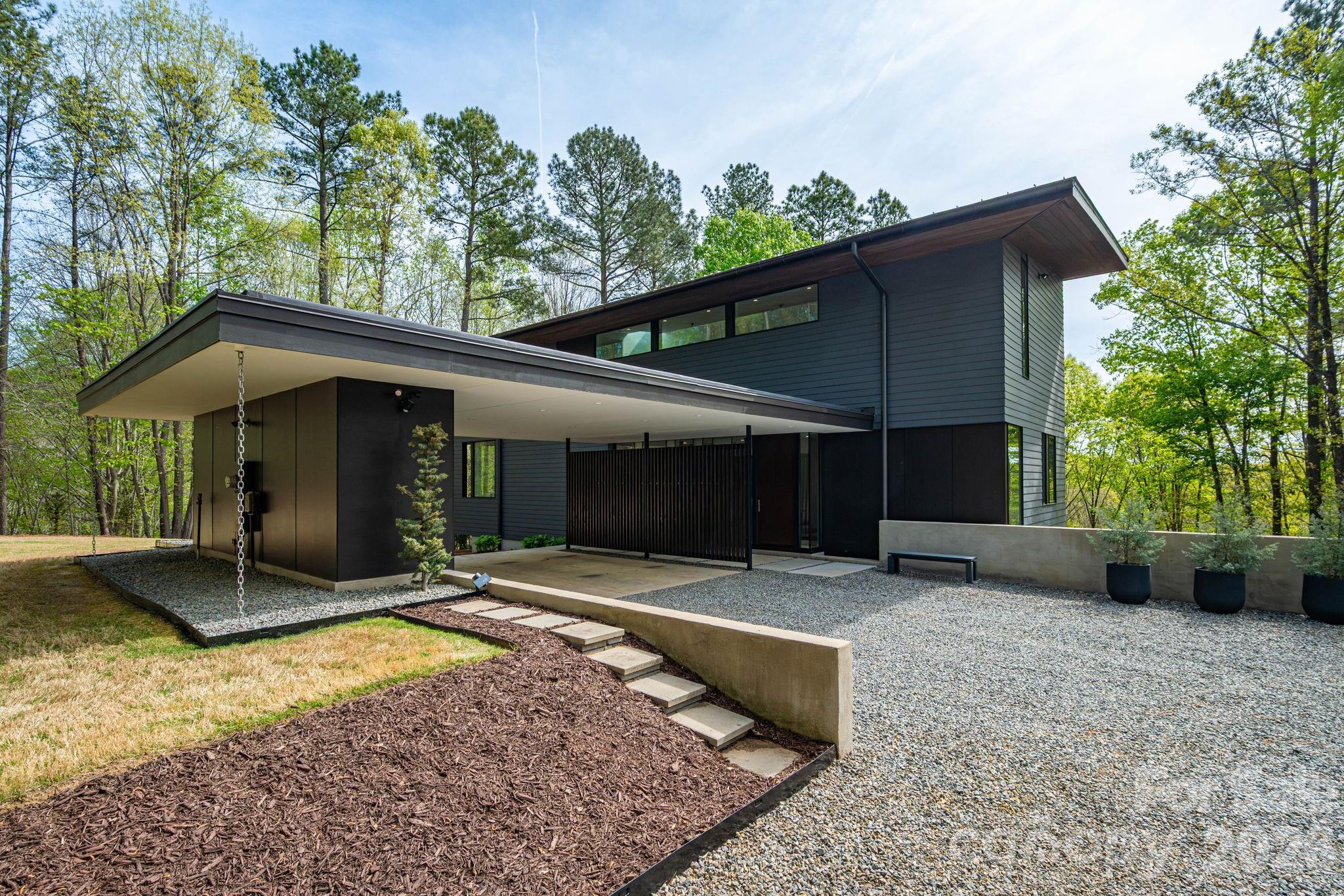 Where Architecture Meets the Water's Edge

 

Some homes are simply places to live. This one is an experience — a multi-award-winning architectural masterpiece where modern minimalism, nature, and lakefront living converge in extraordinary harmony. Poised on more than ten wooded, private acres with over 200 feet of unspoiled shoreline, this residence offers a rare kind of freedom: total privacy, total connection.

 

Step inside and the outside follows you. Commercial-scale glass windows and walls dissolve the boundary between interior and landscape, flooding every room with endless water and woodland views. The open floor plan flows naturally — perfect for quiet mornings, effortless entertaining, and everything in between. Enclosed gas fireplaces anchor both the main living room and lower den, offering warmth and ambiance year-round.

The chef-designed kitchen is a study in precision: Bosch, Braun, and Wolf appliances paired with custom extra-deep, soft-close wood cabinetry and waterfall granite countertops. Every surface considered, every detail intentional. A large media room is perfect for movie nights, and the open plan makes hosting feel effortless.

 

Each bedroom is a private retreat, fully ensuite with soundproof walls between spaces — ensuring privacy and quiet are never an afterthought. The east-facing primary suite feels like sleeping in the tree canopy itself, waking to morning light filtering through the leaves. Its Zen spa bathroom features heated floors, a freestanding volcanic limestone soaking tub, dual sinks, and a generous glass shower.

 

Outdoors, life expands. A huge deck with powered awning, open patio, and private covered porch create seamless spaces for gathering or solitude. Your private permitted dock — with boat slip, generous seating areas, and a peaceful cove setting — makes every day on the lake effortlessly yours. A mile of wooded trails wind through the property for morning walks and evening escapes.

 

Thoughtfully built for the future: plumbing stub-ups support an additional full bath and expansion of an existing half-bath, while a large unfinished storage and mechanical room offer room to grow. A fully integrated, hidden network on a dedicated internet line keeps the home seamlessly connected — invisibly, as it should be. Highly efficient materials and construction keep energy costs impressively low.

 

This is not just a home. It is a private world — award-winning, waterfront, and entirely your own.