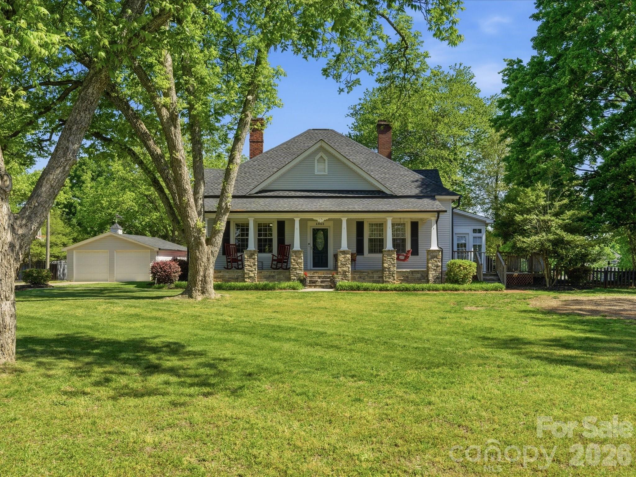 History meets the 21st century in this gorgeous estate located on 2.5 acres.  Although it was originally built in the late 1800s, it has been updated and enlarged in recent years to create a timeless home for new owners.  From the moment you arrive on the property, you will be enthralled with the serene setting that surrounds this homestead.  The rocking chair front porch welcomes visitors and provides the perfect spot to start each morning or end each evening in peace and tranquility.  The character in this home is enhanced by the perfect combination of original craftsmanship and modern-day conveniences.  The living room and dining room resonate with charm as you are taken back in time.  The galley-style kitchen, with stainless appliances and granite countertops, provides the new owners with good space to prepare meals and overlooks the breakfast area and family room.  The primary bedroom, with en suite bath and direct access to the sunroom, is a wonderful haven to enjoy.  Two additional bedrooms (one of which has been converted to a hobby/office space) complete the home.  Looking for garage space?  You will have multiple options, including a 26’ x 36’ insulated workshop with garage doors that offers tremendous potential, a double garage, and a storage building (conveying “as is”) that has been reported to be from the original construction – over one hundred years ago.  Outdoor living space is perfect in this one-of-a-kind property that is ready to welcome new residents that are ready to start a new chapter in a home that is filled with historical appeal.