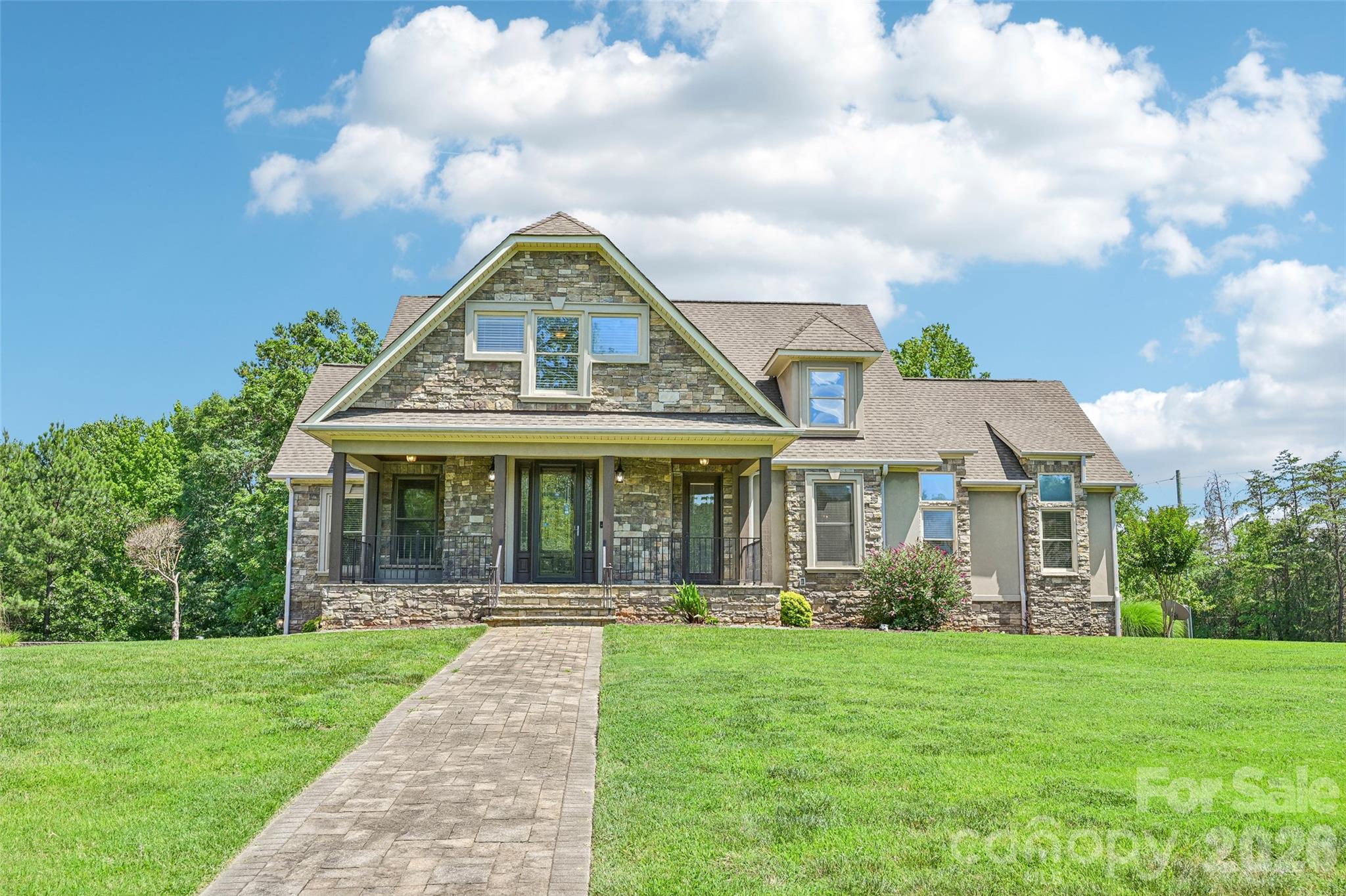 2016 Rocky Stream Rd is a 2-story York custom home built in 2007, provides 6 bedrooms and 7 bathrooms across 6,347 square feet. The kitchen features wood cabinetry, granite countertops, a center island, and stainless steel appliances including a wall oven and gas range. Multiple living areas span the main and lower levels, including a formal dining room with wainscoting, a living area with a fireplace, and a lower-level recreation space. The primary bathroom includes a double vanity, soaking tub, and separate walk-in shower. A covered wraparound porch and large deck overlook the expansive yard, and a 4-car attached garage completes this large custom residence. Included 100-Day Home Warranty with buyer activation