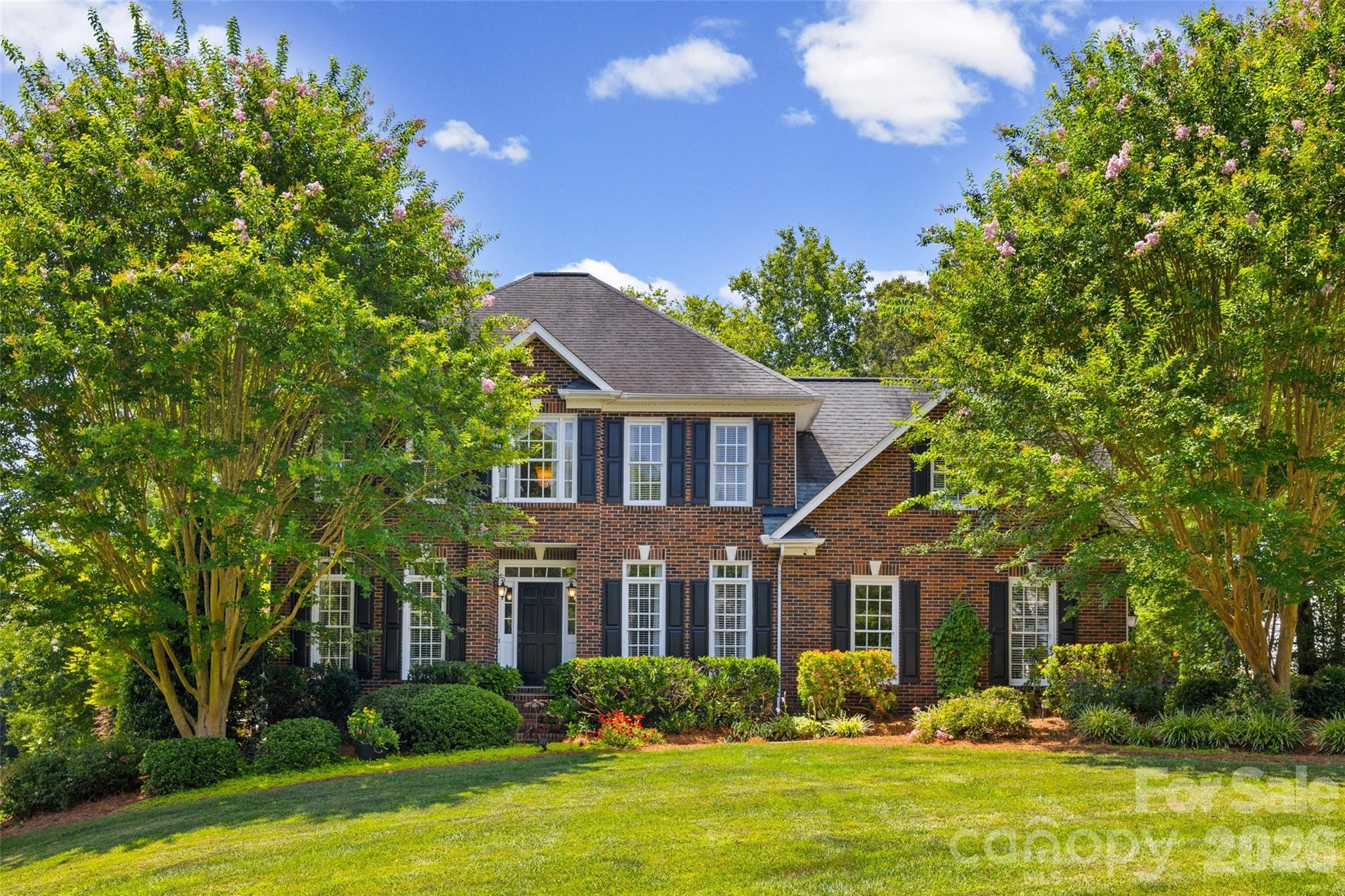 Rarely does a home like this come to market under $600,000.
Calling all flower lovers, garden enthusiasts, and buyers searching for the charm of established Waxhaw living—this is the one you've been waiting for. Situated on an incredible half-acre corner lot in the highly desirable Waxhaw/Wesley Chapel area, this meticulously maintained full brick home offers something that's becoming harder and harder to find: generous homesites, mature trees, timeless curb appeal, and a setting that feels like your own private retreat.
From the moment you arrive, you'll be captivated by the breathtaking landscaping. Bursting with colorful blooms, lush gardens, and beautiful mature trees, the grounds create a peaceful, storybook setting that changes with every season and offers exceptional privacy.
Inside, rich hardwood floors welcome you into a dramatic two-story foyer, a dedicated office and formal dining room. The inviting family room is anchored by a cozy gas fireplace and framed by oversized windows that flood the space with natural light while showcasing the beautiful backyard views.
The kitchen flows effortlessly into the breakfast area and an expansive flex space that offers endless possibilities. Whether you envision a spacious great room, bourbon lounge, game room, media room, or an oversized private office, this versatile area adapts to your lifestyle.
Upstairs, the spacious primary suite offers a relaxing escape with lots of natural light, and a primary bathroom featuring a tub and shower. Two additional guest bedrooms, a full bath, and a generous bonus room provide plenty of space for guests, hobbies, or play. Then there's the backyard.
The soaring screened porch is the perfect extension of the home, creating an ideal place to enjoy morning coffee, afternoon breezes, or evenings with friends. Step outside to two beautifully designed paver patios and gather around the firepit while surrounded by the beauty of the professionally landscaped yard.
Located just minutes from Wesley Chapel Village Commons, shopping, dining, and everyday conveniences, this home offers the perfect combination of location, space, and character.Homes with this much personality, privacy, and established beauty rarely become available. If you've been waiting for a home that feels different from everything else on the market, your search may just be over. Showing start Friday 7/10/26. Open house Saturday 7/11/26.