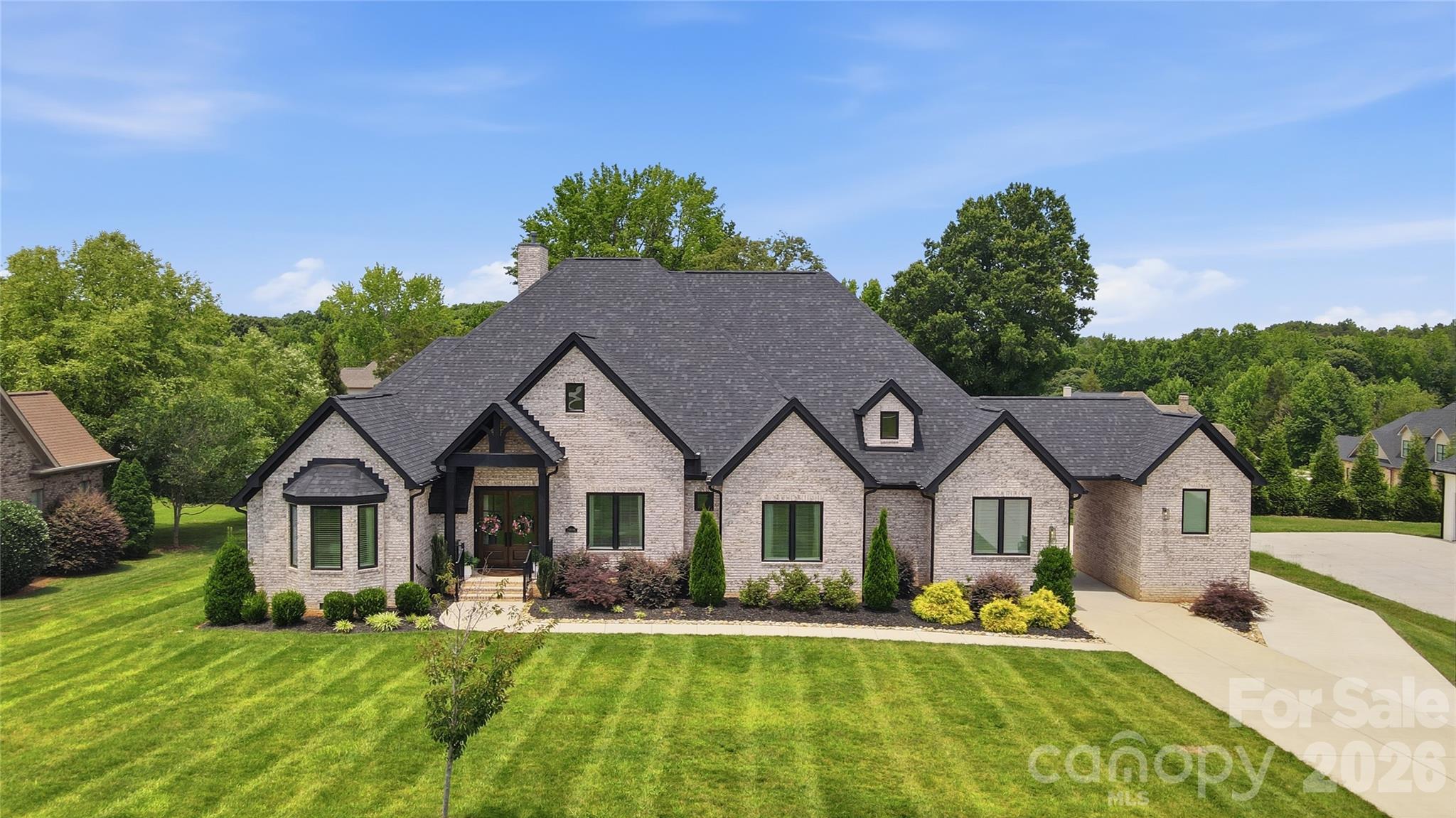 Exceptional custom-built single-story residence offering five bedrooms, four and a half baths, and a thoughtfully designed finished room over the garage. From the moment you enter through the impressive double 8-foot entry doors, you'll appreciate the home's refined craftsmanship, elegant finishes, and expansive open-concept design.

Soaring ceilings, rich hardwood flooring, upgraded trim details, crown molding, custom millwork, and designer lighting create a sophisticated atmosphere throughout. Every bedroom features a custom-designed closet, providing both beauty and functionality.

The private owner's retreat is a true sanctuary, highlighted by a spa-inspired bath featuring a stunning marble shower, separate soaking area, and direct access to an oversized custom walk-in closet.

At the heart of the home, the chef's kitchen showcases premium stainless steel appliances, a gas range with professional exhaust hood, quartz countertops, an oversized center island with breakfast bar seating, and a convenient butler's pantry.

Outdoor living is equally impressive, with a spacious covered deck overlooking a large, level backyard offering endless possibilities for recreation, gatherings, and future outdoor enhancements. The property also includes both an attached two-car garage and a detached single-car garage, providing exceptional flexibility for vehicles, storage, hobbies, or workshop space. For added convenience and future-ready living, the home is equipped with a dedicated electric vehicle (EV) charging station.

Meticulously crafted and beautifully appointed, this residence blends timeless elegance with modern comfort, creating an extraordinary place to call home.    *NOTE:  NO sign in yard