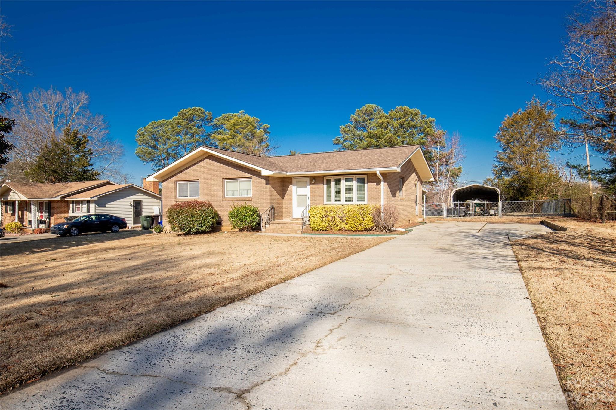 Discover the epitome of warmth in this inviting brick ranch home. Featuring three bedrooms, one full bath, and one-half bath off of the primary bedroom. A charming sitting room with a bay window bathes the space in natural light. Cozy up by the wood-burning fireplace, and step outside to a fenced backyard with a covered patio—perfect for relaxation. Make this charming haven yours!