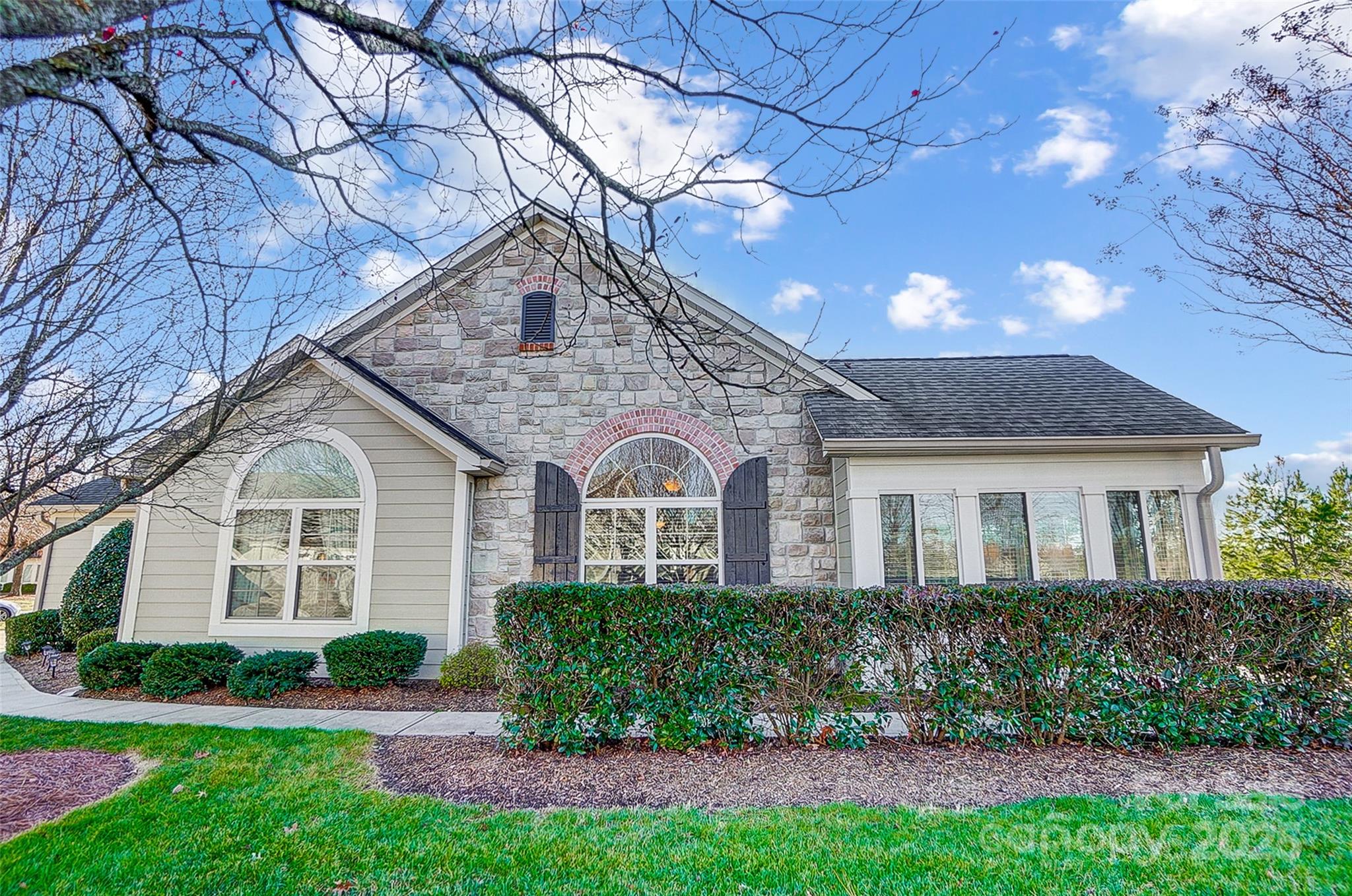 Welcome to this stunning end-unit Canterbury model in the highly sought-after Stonecrest Villas of Tega Cay.Tucked away from the road, this charming ranch home offers the perfect balance of privacy and convenience. The lush landscaping & green space provide a serene backdrop. You will love the bright & open floor plan w vaulted ceilings & natural light streaming through large windows. The spacious living room, w a cozy gas fireplace, seamlessly flows into the beautiful dining area that could also function as a stunning sunroom. The kitchen is a chef’s dream. The primary suite offers a tranquil retreat. Outside, the patio offers a peaceful spot to relax & enjoy the beautiful surroundings. Resort-style living, including an outdoor pool, clubhouse, library, fitness center, parks, pergolas, & sidewalks. HOA covers water, sewer, landscaping, trash collection, & exterior/roof maintenance. Easy access to dining, shopping, this home offers the best of both comfort and convenience. Hurry home!