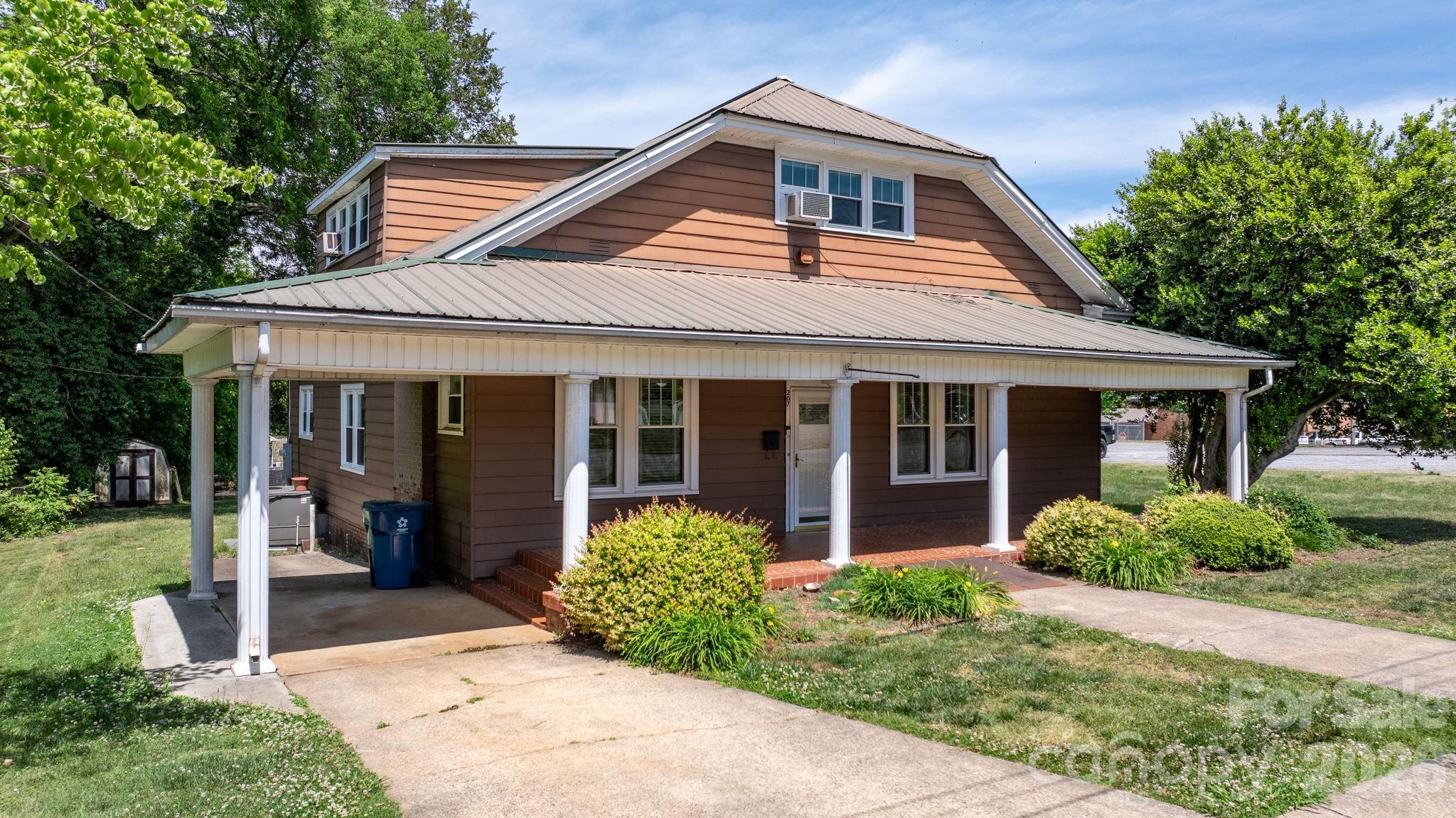 All new flooring in 4 ROOMS, plus a Price Reduction and $15,000 Seller Credit for further Updates! A rare opportunity to own one of Maiden's most charming and solidly-built Craftsman Bungalows.  With 4 BR and 2 full baths, this home is situated on Main Street in the heart of the "Biggest Little Football Town In the World," With a .38 acre lot, this gracious 1930s home offers nearly 2,900 square feet of generous, light-filled rooms — including spaces with soaring 10-foot ceilings and character that is simply aren't found in modern construction. You already have a metal roof, replacement windows,  and updated wiring so 3 typical major renovation expenses have been met.  The home is move-in ready with great bones, and presents an exciting canvas for the buyer with vision. The oversized kitchen and dining area is brimming with potential — ready for the stunning renovation it deserves. Original hardwood floors grace multiple rooms, some new flooring is being put down as well. Warm knotty pine paneling adds character. Close to everything, you can walk to Church, an ice cream shop, or the local barber.  You won't find a nicer home for this price with this much square footage.  Only 43 mintues to Charlotte Douglas International Airport.