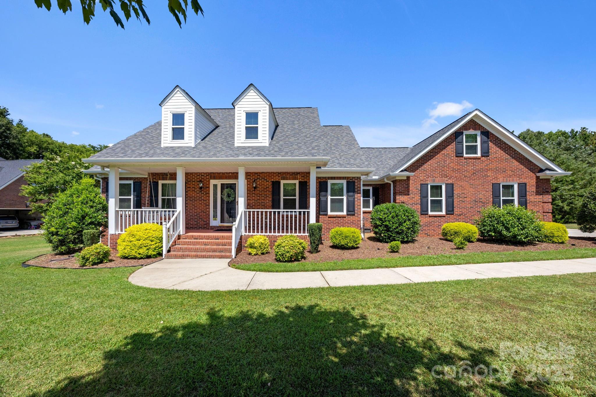 RARE 1 ACRE LOT in Fort Mill with NO HOA! This beautifully maintained, one-owner full brick ranch offers classic curb appeal and modern comfort. Featuring a large garage and a welcoming rocking chair front porch that leads into a light-filled interior with hardwood floors, vaulted ceilings, and an open-concept layout. The gourmet kitchen features granite counters, stainless appliances, and custom pull-out cabinetry—perfect for entertaining. The vaulted primary suite includes a spa-like bath with whirlpool tub, separate shower, and a large walk-in closet. Two guest rooms and a large walk-up attic can be converted to an additional living space. Enjoy the upgraded 3-season sunroom with tile floors and EZE-Breeze windows, plus a paver patio overlooking the hard-to-find flat backyard. Move-in ready with thoughtful updates throughout—this one is truly a rare find!